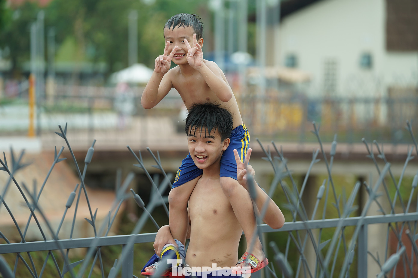 "Thường cuối tuần tụi con được ba chở đi tận sở thú, Đầm Sen chơi. Giờ có khu công viên này gần nhà lại có hồ bơi. Tụi con vừa bơi xong, mát lắm" - em Lê Bảo An (ngụ xã Bà Điểm, huyện Hóc Môn) đang cõng em trai Lê Bảo Khang theo bố ra bãi xe chia sẻ.