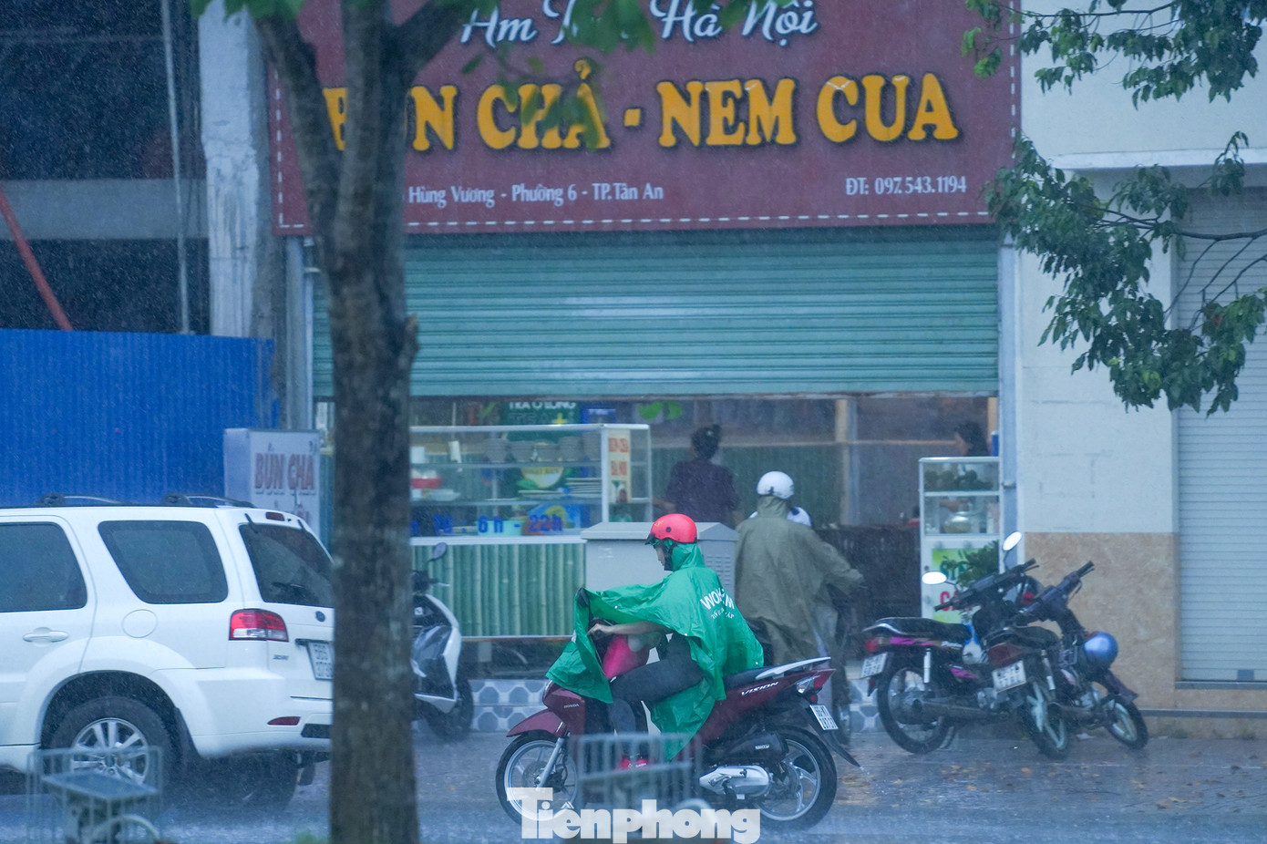 Một quán ăn phải hạ bớt cửa cuốn để tránh tạt nước mưa.