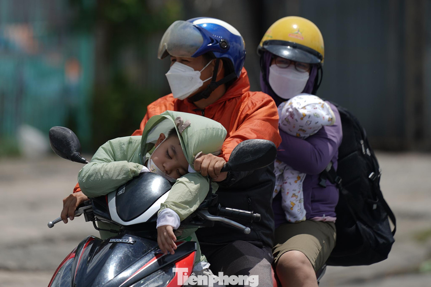 Hành trình dài khiến người lớn và trẻ nhỏ mệt mỏi. Một em bé ngủ gục trên tay lái.