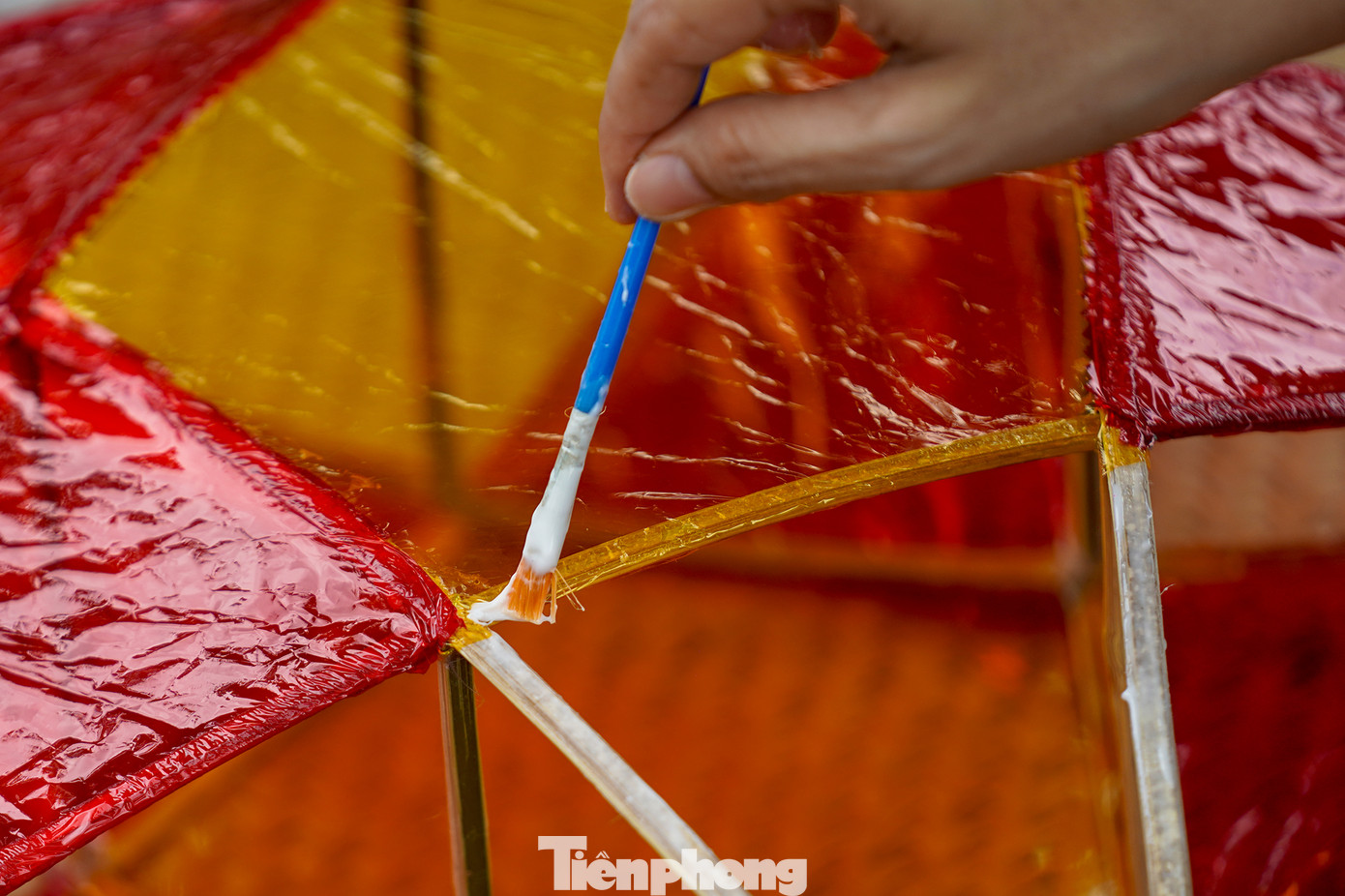 "Công đoạn nào khó thì người lớn sẽ làm phụ các con. Mấy bé thích cầm cọ quét keo và dán giấy kính. Hoạt động này cũng một phần giáo dục các bé về nét văn hóa mà ngày nay ít thấy nữa khi lồng đèn gắn pin, phát nhạc bán đại trà. Chiếc đèn ông sao truyền thống có hình sao vàng năm cánh. Đây cũng là hình ảnh quen thuộc chúng ta vẫn thường thấy trên lá quốc kỳ", chị Hồng Nhung (áo trắng) chia sẻ.