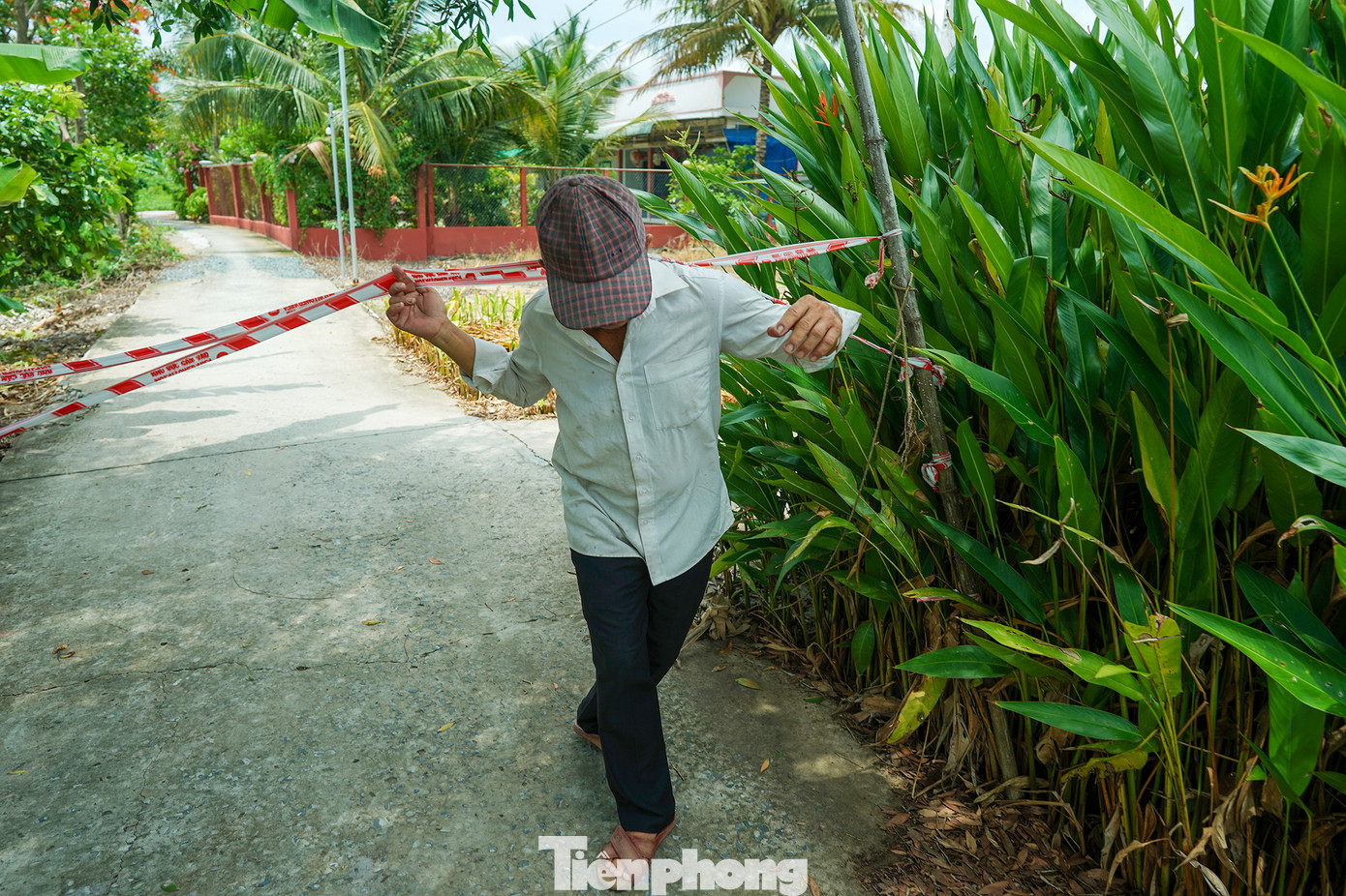 Ông Luận chui qua phần rào cảnh báo phía bên kia đoạn sạt lở để chỉ nơi người dân bị cô lập, phải đi nhờ lối tắt.