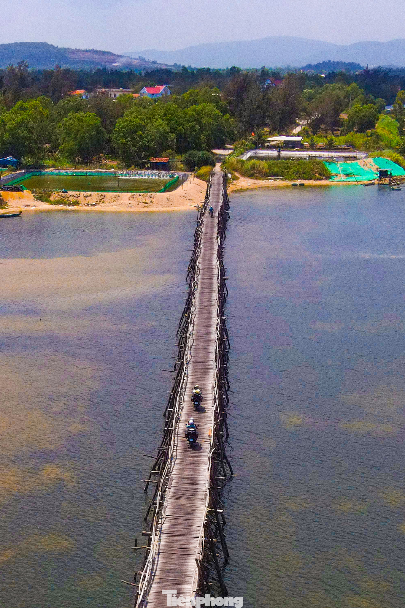 Dưới chân cầu luôn “túc trực” các cây gỗ phi lao, chỉ cần tấm ván hỏng là có thể thay thế sửa chữa ngay để tránh ảnh hưởng đến tình hình giao thông đi lại của bà con. Đến với cầu Ông Cọp, bạn không chỉ cảm thấy an yên bởi sự mộc mạc giản dị của chiếc cầu gỗ mà còn phải trầm trồ bởi khung cảnh thiên nhiên ngoạn mục tại nơi đây.