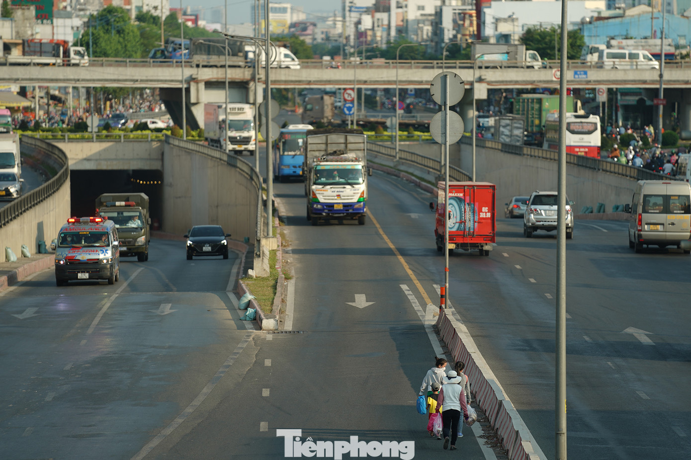 Người dân chọn cách băng ngang quốc lộ 22 để sang bến xe An Sương giữa dòng phương tiện đông đúc.
