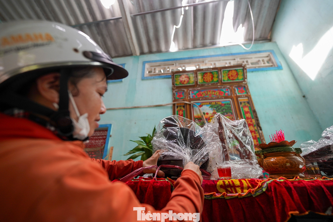 Con gái của bà Bé Hai đang bịt lại chiếc lư gỗ. Sau trận lốc, vật dụng trên bàn thờ nhà bà Bé Hai bị gió cuốn phăng.