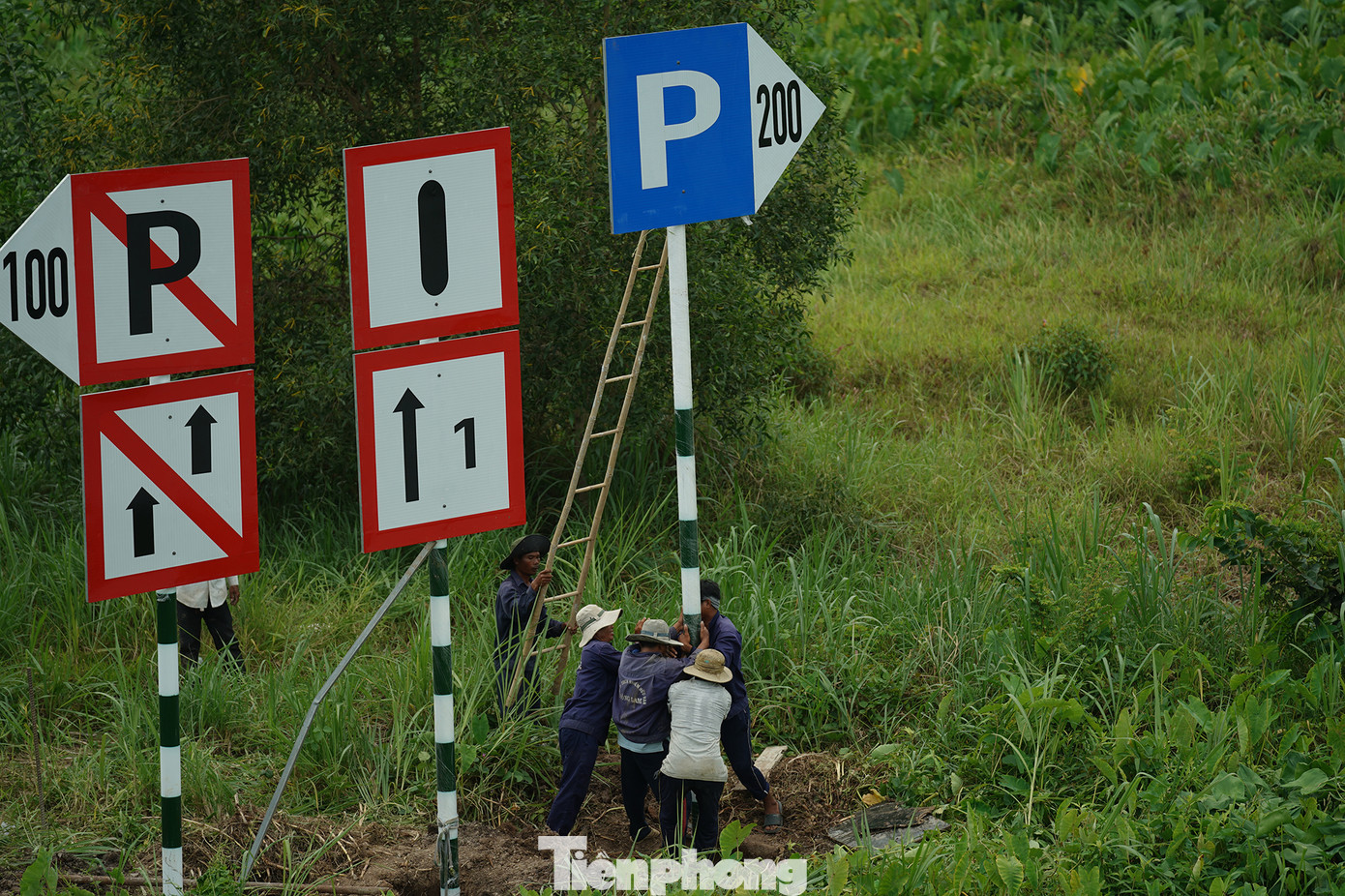Công nhân đang thi công lắp biển báo ngay dưới chân cầu Bảo Định.