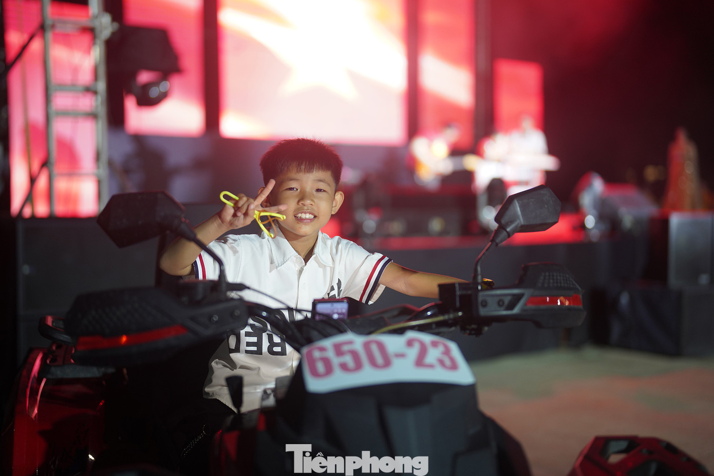 Bé Nguyễn Lê Thiên Phúc (9 tuổi, ngụ TP Biên Hoà, Đồng Nai) thích thú chụp ảnh cùng chiếc mô tô vượt địa hình. &quot;Đó đến giờ người dân xung quanh đây muốn xem pháo hoa như thế nào phải vô trung tâm Quận 1 (TPHCM) nên này biết có bắn ở khu vực này thì háo hức lắm. Nhóc Phúc nó nghe pháo hoa nên đòi tôi phải dẫn vô đây từ chiều&quot;, phụ huynh của Phúc chia sẻ.
