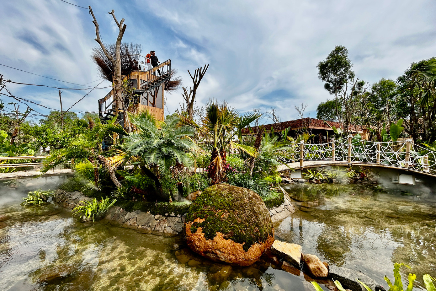 Quán cà phê được bao bọc, phủ kín bởi hệ thực vật phong phú, tạo cảm giác như một khu rừng nguyên sinh với khí hậu mát mẻ được tạo ra từ các máy phun sương.