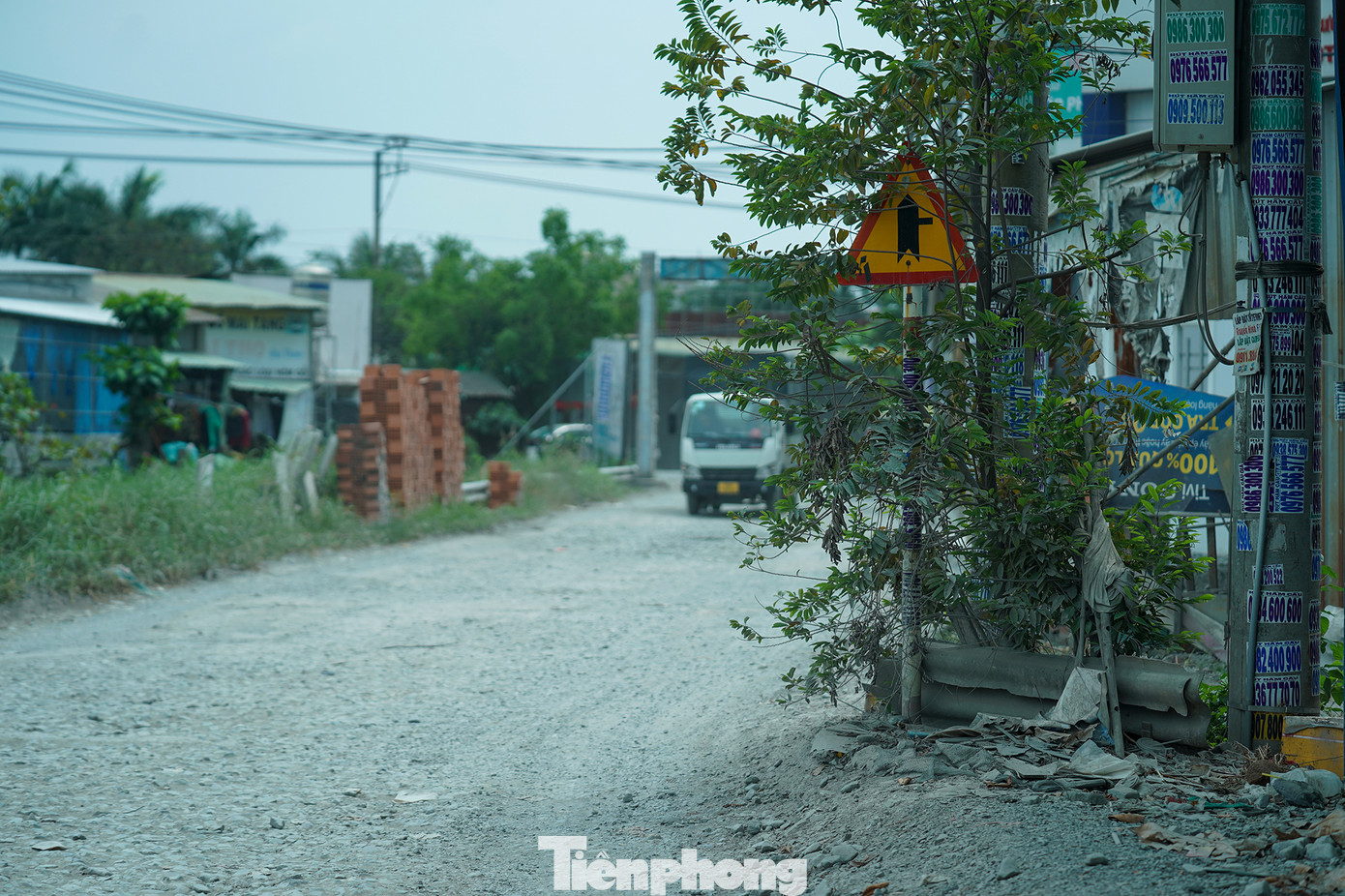 Bụi mù bám chặt vào cây cối, nhà dân hai bên đường.