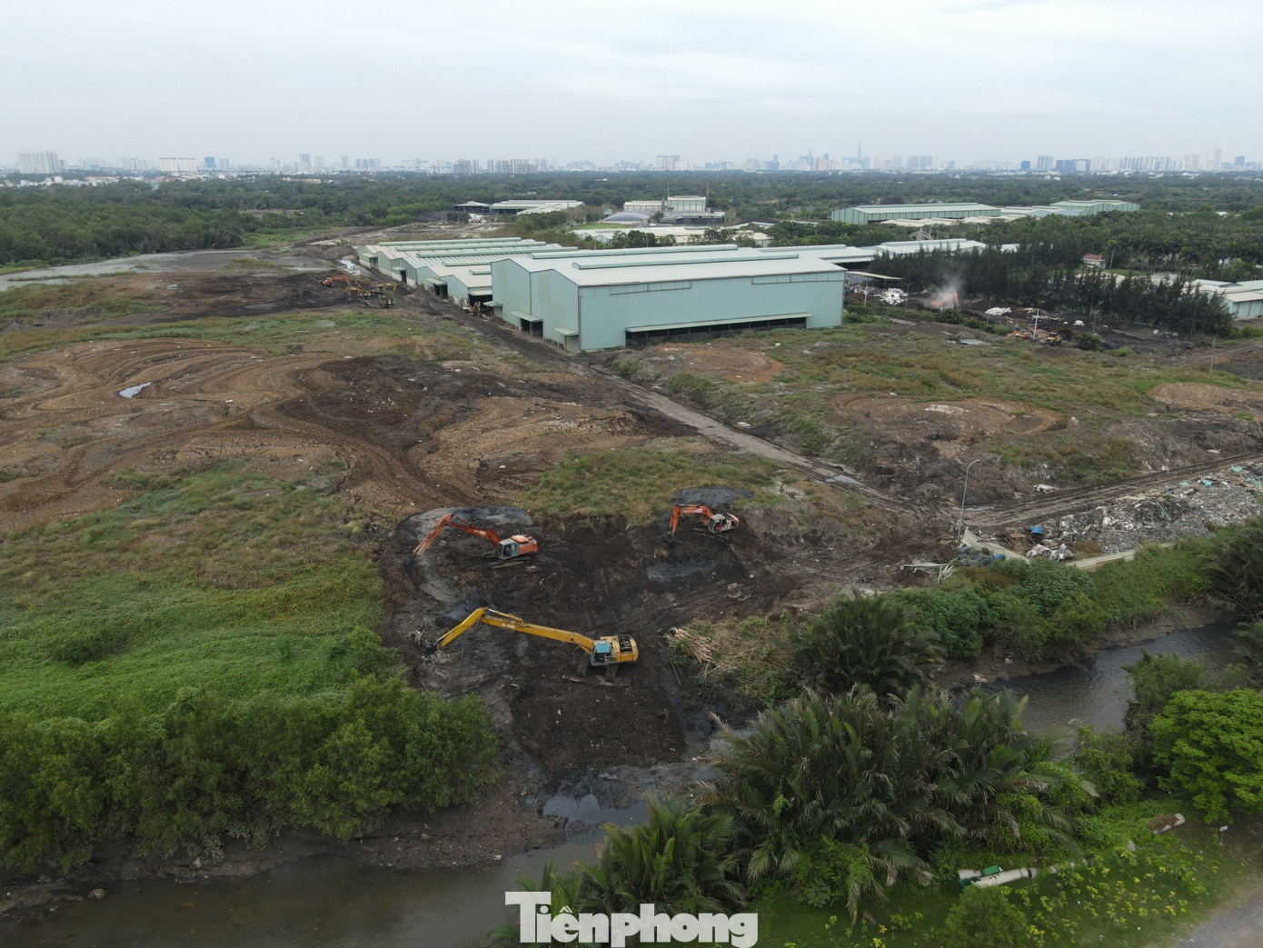 Hình ảnh ghi nhận máy xúc thi công đưa bùn đen ra thẳng con rạch nhỏ cạnh khu nghĩa trang Đa Phước.