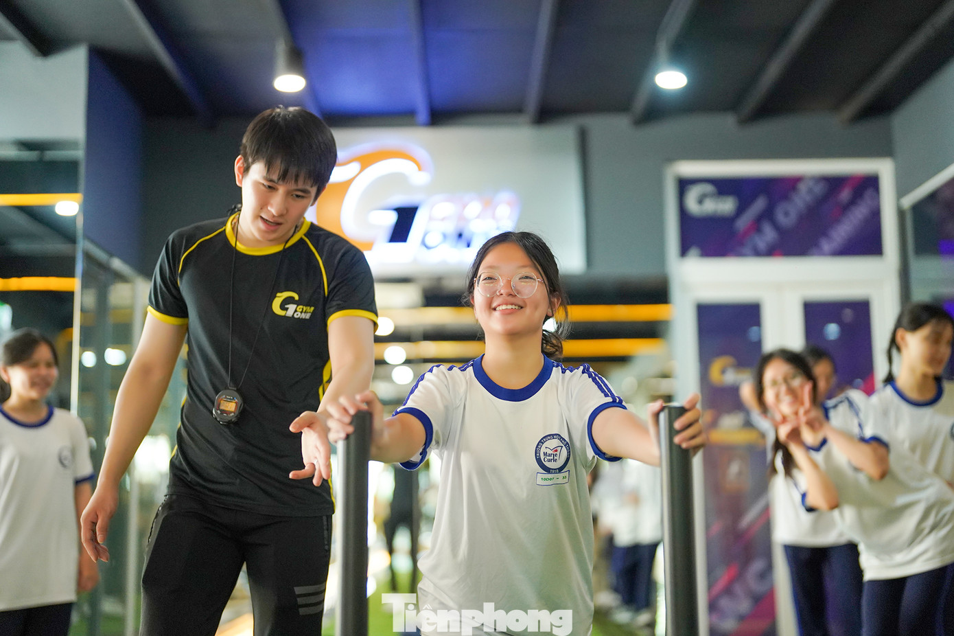 Theo thầy Hào, ở lứa tuổi học sinh THPT, khi đa dạng hóa các loại vận động thì các em sẽ phát triển đều hơn. Ví dụ, tập ngoài sân với bóng rổ, bóng chuyền thì đa phần các em phát triển kỹ năng, kỹ thuật, sự dẻo dai, còn tập GYM thì phát triển sức mạnh, thể lực. Trong ảnh, PT hướng dẫn em học sinh luyện tập thể lực.