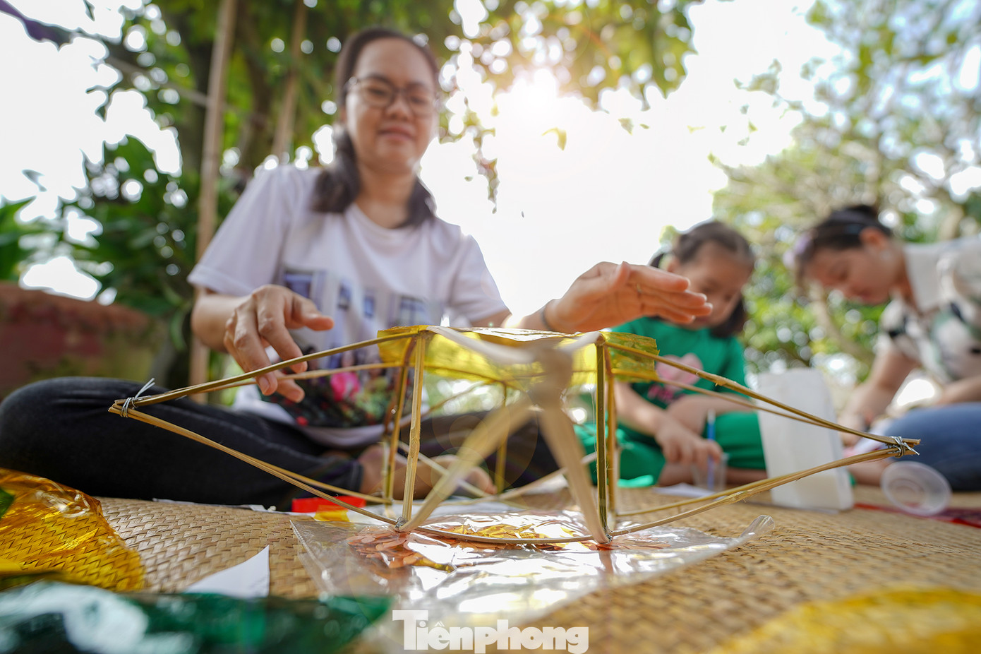 "Công đoạn nào khó thì người lớn sẽ làm phụ các con. Mấy bé thích cầm cọ quét keo và dán giấy kính. Hoạt động này cũng một phần giáo dục các bé về nét văn hóa mà ngày nay ít thấy nữa khi lồng đèn gắn pin, phát nhạc bán đại trà. Chiếc đèn ông sao truyền thống có hình sao vàng năm cánh. Đây cũng là hình ảnh quen thuộc chúng ta vẫn thường thấy trên lá quốc kỳ", chị Hồng Nhung (áo trắng) chia sẻ.