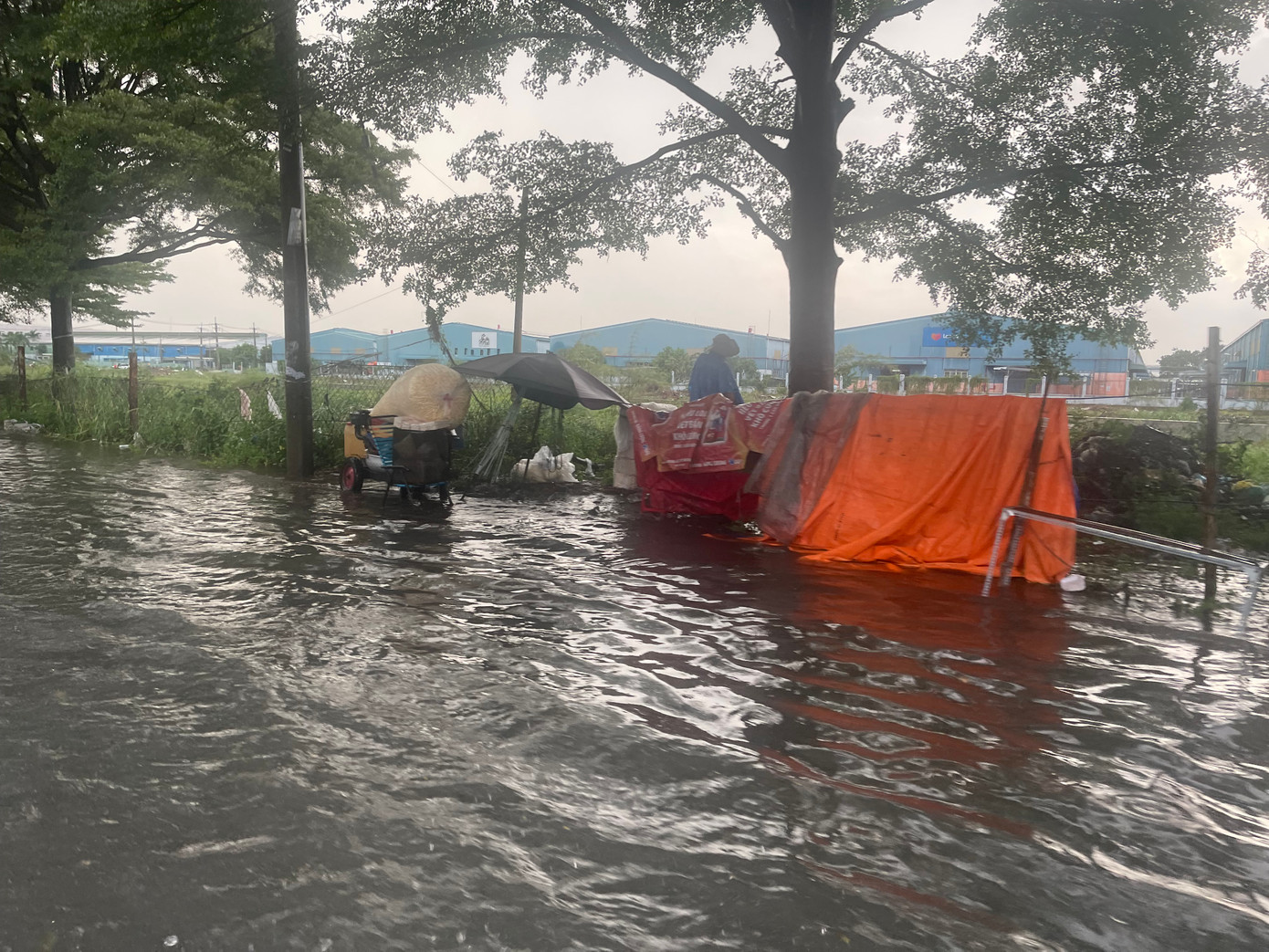 Cơn mưa lớn khiến con kênh nước đen tràn lên mặt đường bốc mùi hôi. Cơn mưa lớn khiến con kênh nước đen tràn lên mặt đường bốc mùi hôi.