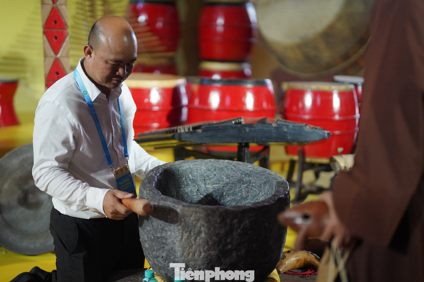 Du khách thích thú trải nghiệm gõ thử chiếc chuông bằng đá.