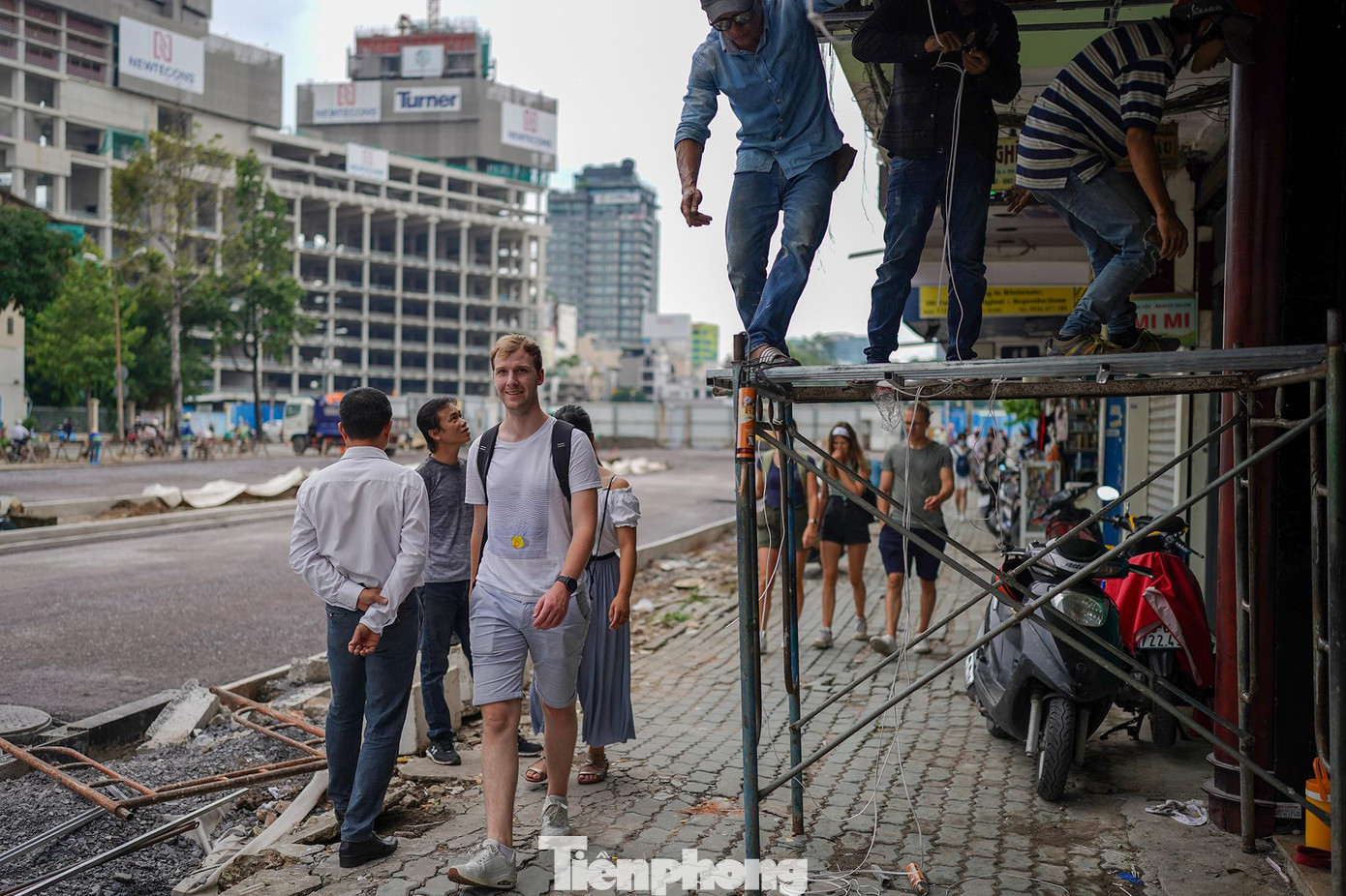 Khách du lịch len qua phần vỉa hè chưa hoàn thiện trên đường Lê Lợi để đi dạo.