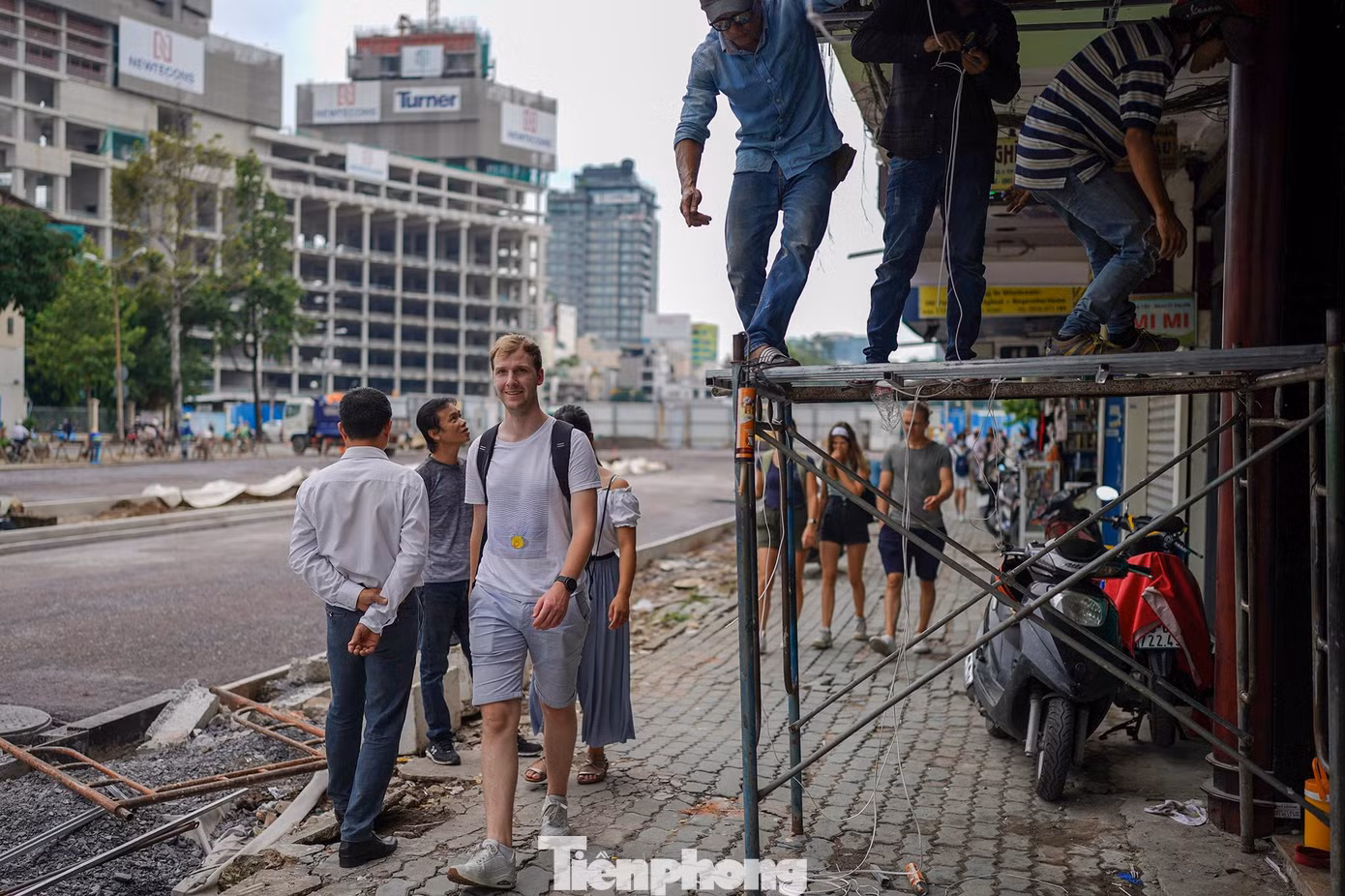 Khách du lịch len qua phần vỉa hè chưa hoàn thiện trên đường Lê Lợi để đi dạo.