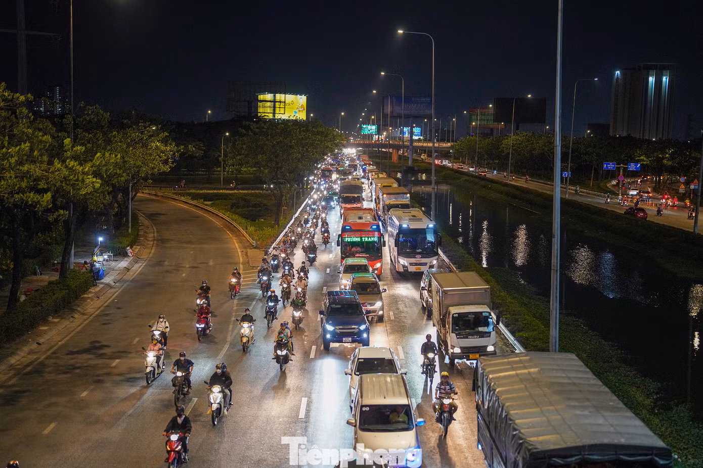 Từ cầu vượt vào đại lộ Võ Văn Kiệt, phương tiện nối nhau kéo dài cho đến ranh giới TPHCM - Long An (đoạn vào huyện Bến Lức). Trong ảnh ngay đoạn đèn tín hiệu, dòng phương tiện nối nhau thành hàng dài hướng lên cầu Bình Điền.