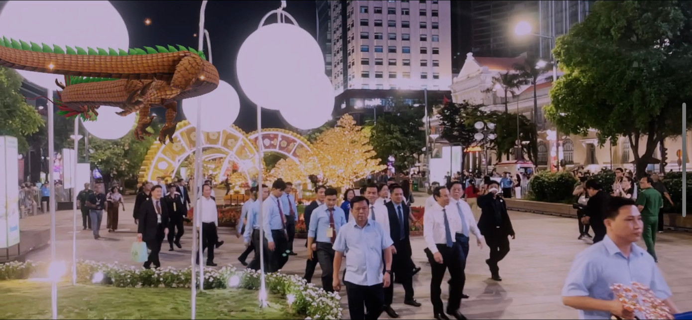 Các vị đại biểu tham quan đường hoa, phía bên trên là chú rồng được quét bằng công nghệ AR. Các vị đại biểu tham quan đường hoa, phía bên trên là chú rồng được quét bằng công nghệ AR.