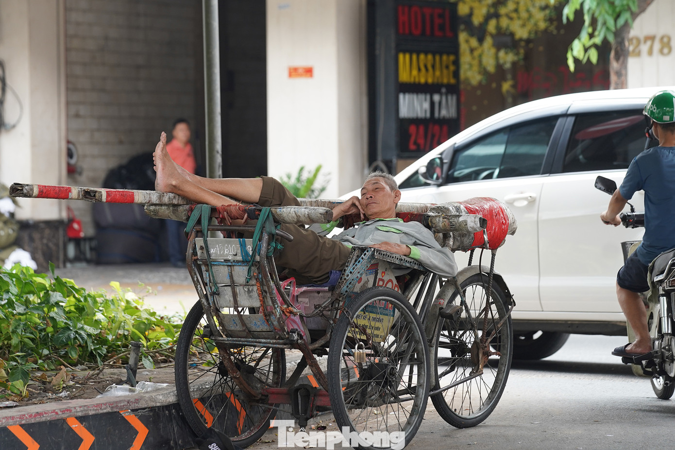 Bác xích lô ngả lưng, tránh nắng dưới chân cầu vượt Hoàng Hoa Thám (quận Tân Bình).