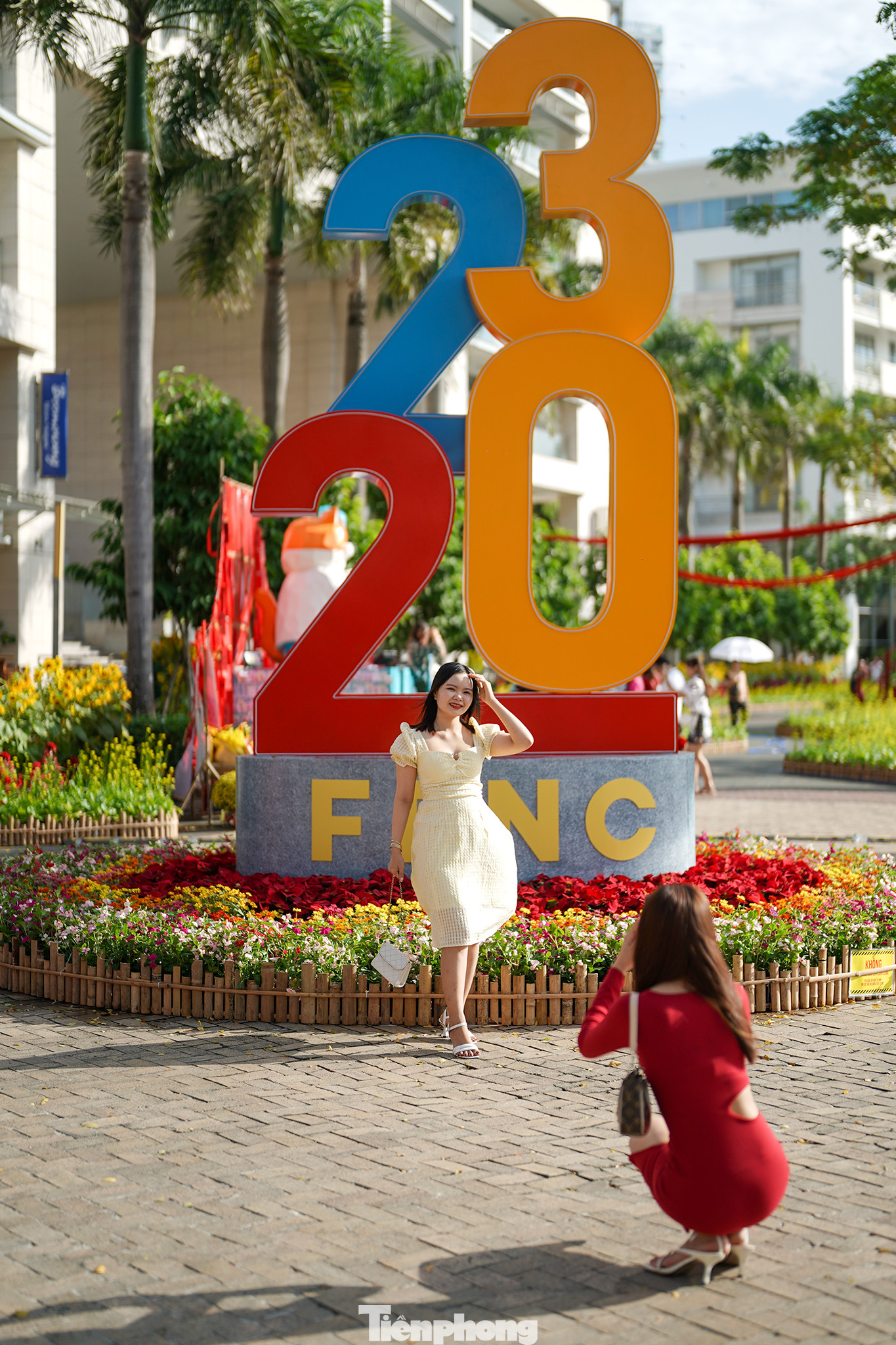 Bạn Lê Thị Kim Phượng đang được người bạn của mình là bạn Lâm Thị Tuyết Nhung chụp ảnh lưu niệm. Hai bạn đi xe từ huyện Cần Giuộc, Long An lên đây để du xuân, chụp ảnh. Sau khi chụp ảnh ở đây, địa điểm tiếp theo của hai bạn sẽ là đường hoa Nguyễn Huệ.