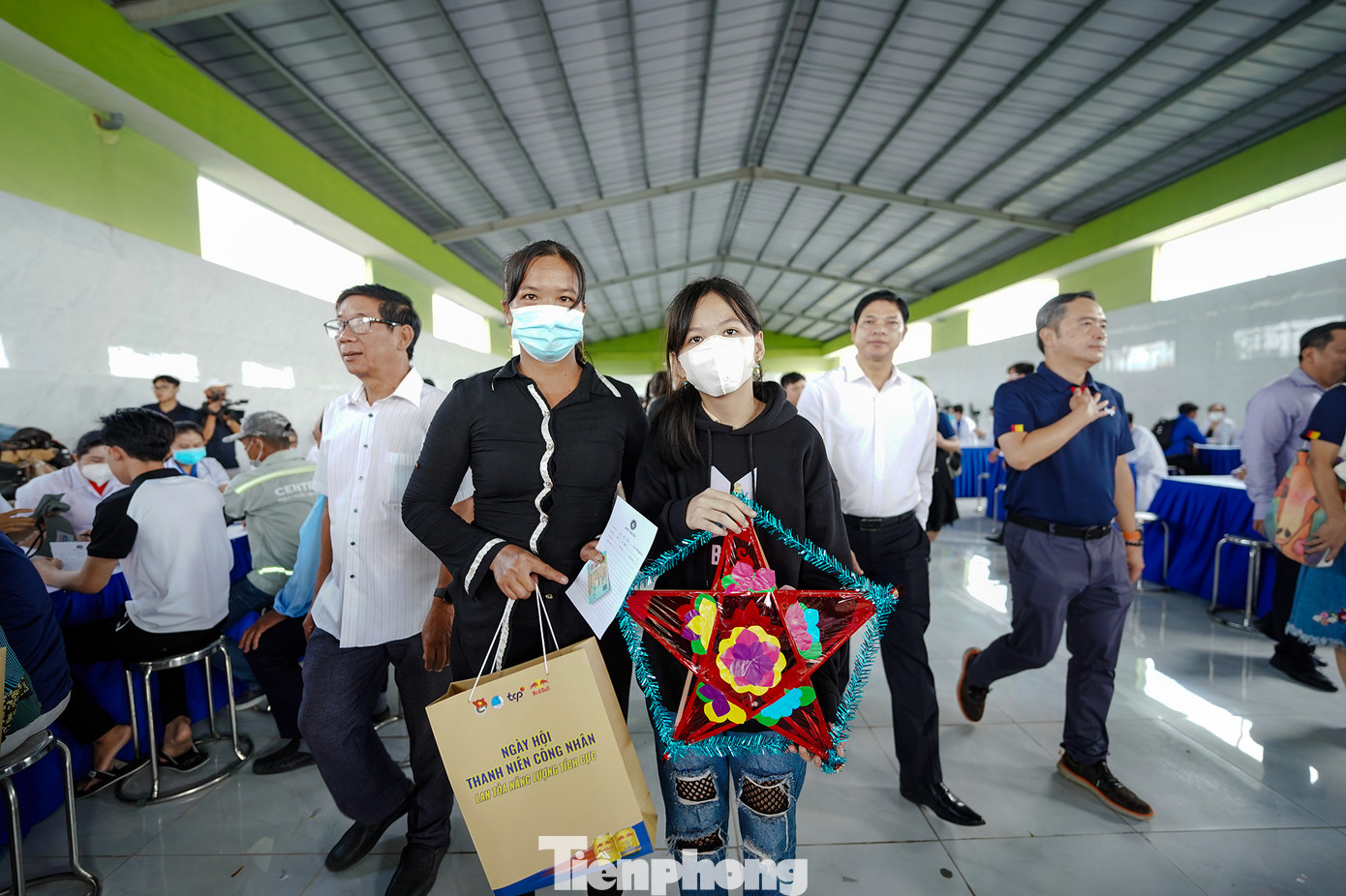 Hai mẹ con chị Trần Mỹ Tiên (ngụ ấp 5, xã Đức Hoà Đông, huyện Đức Hoà) phấn khởi với phần quà của ban tổ chức trên tay khi đang xếp hàng chờ khám bệnh.