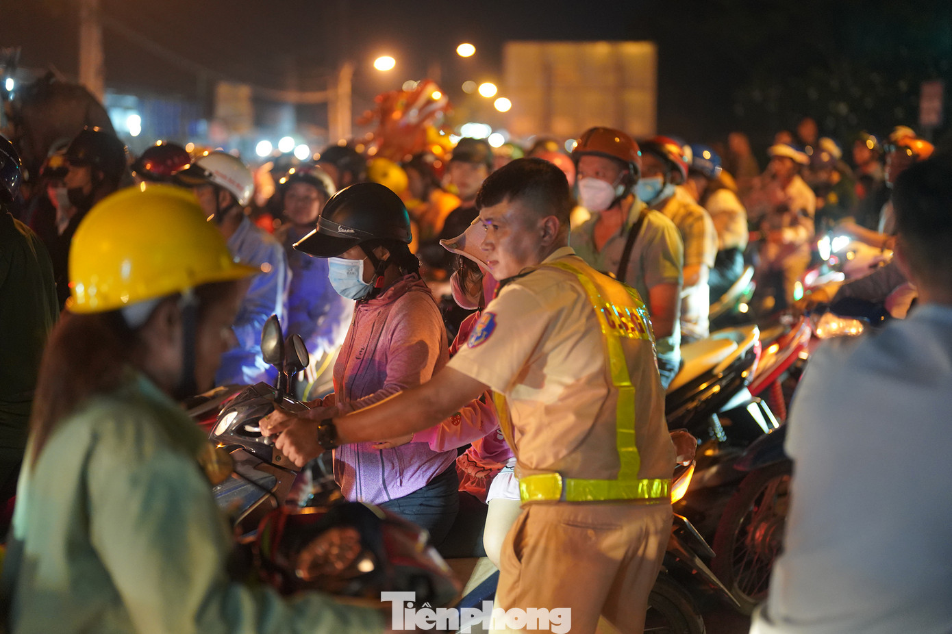 Một chiến sĩ CSGT vất vả hỗ trợ hai mẹ con người này len qua dòng xe cộ sau khi xem xong pháo hoa.