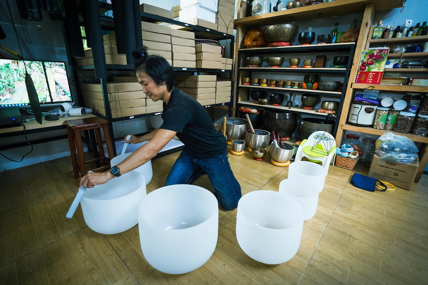 Những chiếc chuông đá này không gõ mà anh Đức dùi cọ quanh thành miệng tạo ra âm thanh cộng hưởng nhẹ nhàng kết hợp với âm thanh giàn chuông gió bên trên hoà thành một giai điệu Thiền.