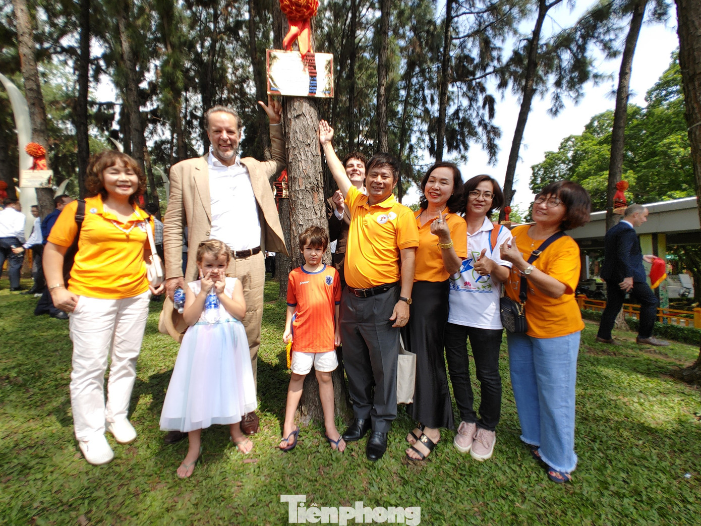 Các đại biểu chụp ảnh lưu niệm tại vườn thông.