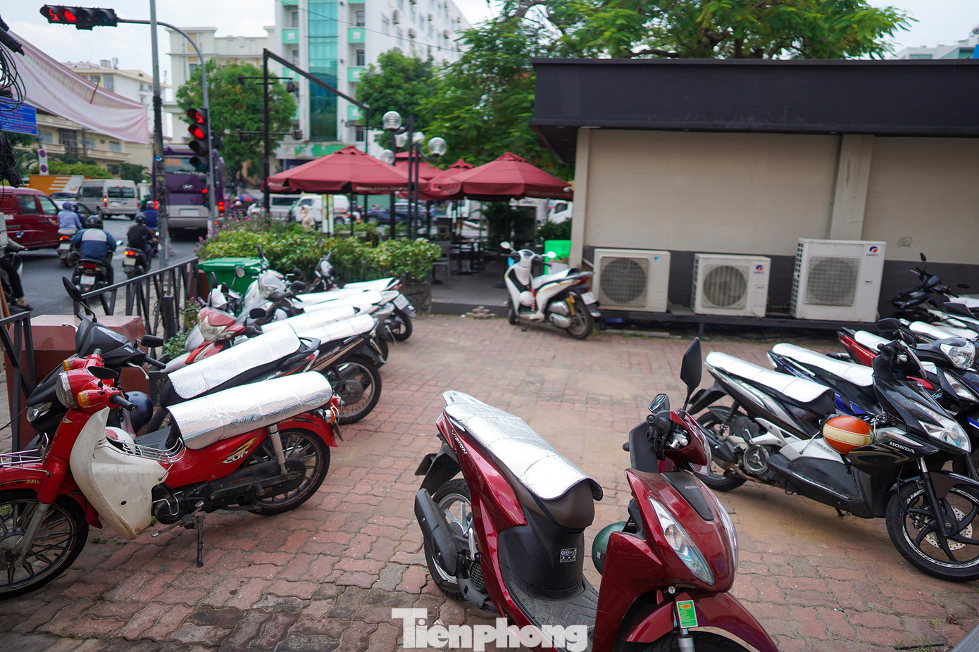 Một quán cà phê đông khách nhờ chuẩn bị tấm che nắng phản quang, bảo vệ xe cho khách.