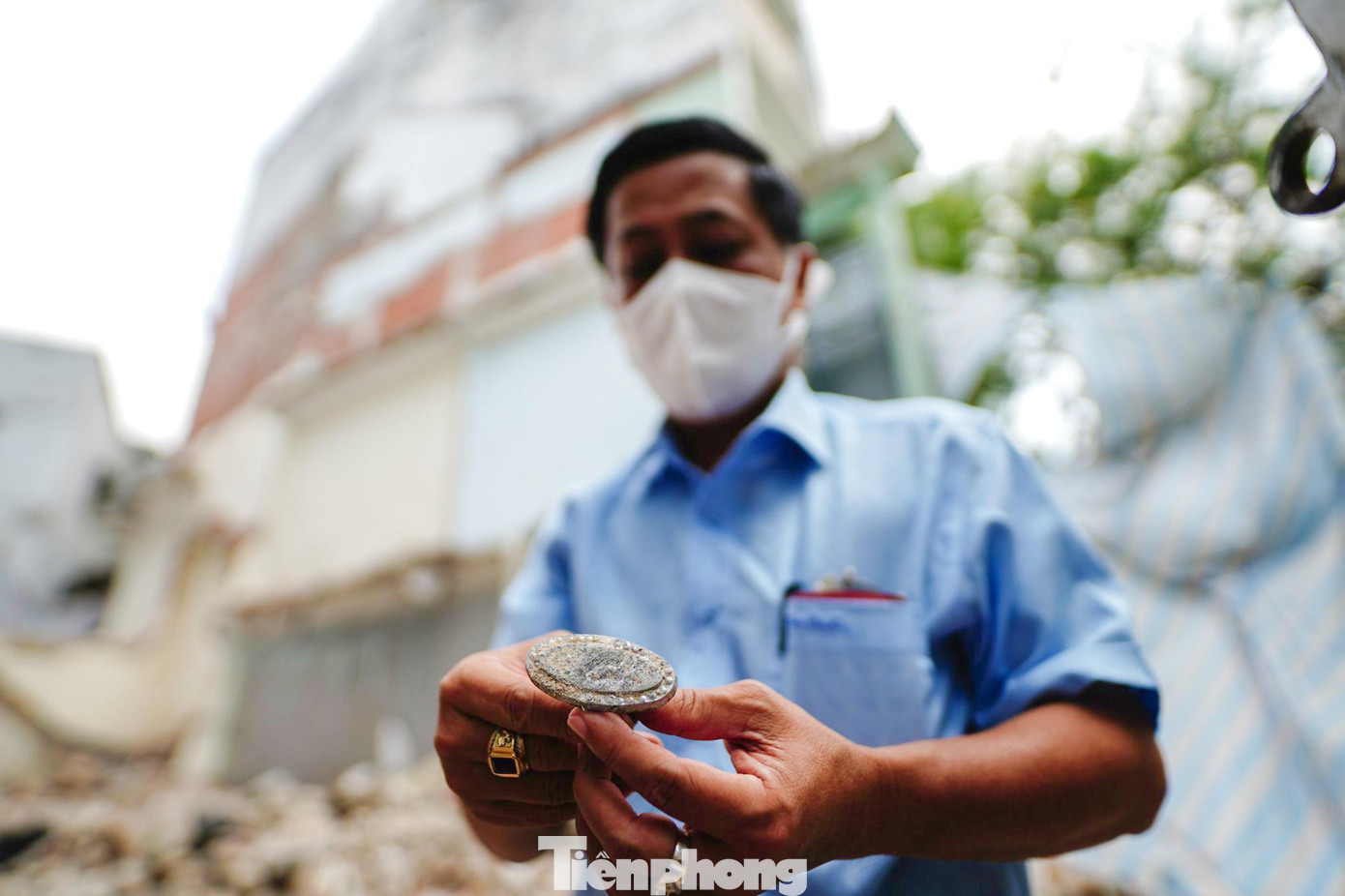 Ông Bình nhặt lại chiếc chốt cửa nguyên bản không còn nguyên vẹn.