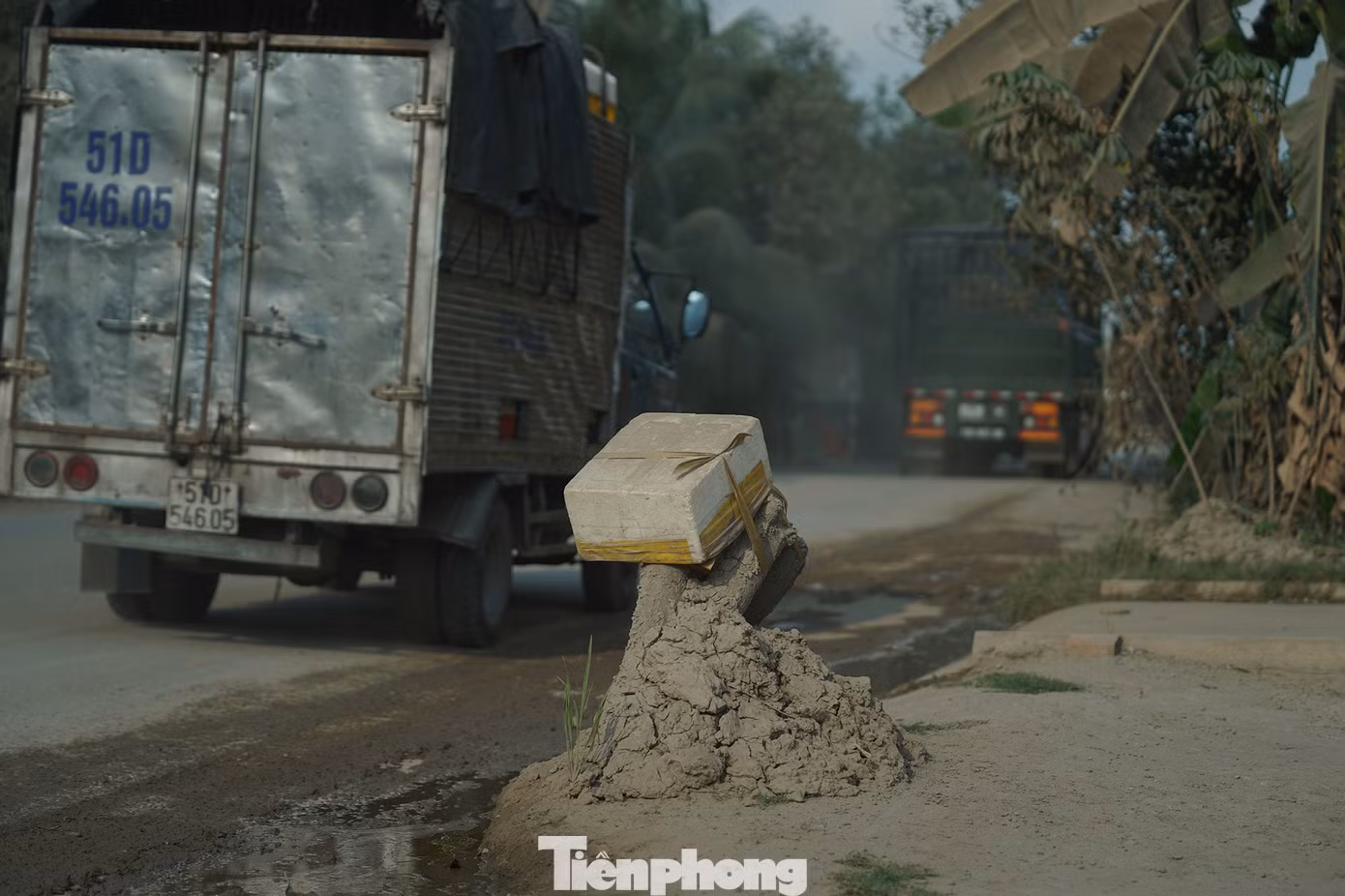 Phần đánh dấu để tránh xe ben, xe tải lấn vào trong nhà. "Không biết có ai cứu chúng tôi không chứ chúng tôi chịu hết nổi rồi. Trời nắng nóng vậy mà cứ 2-3 ngày là tôi phải lấy xẻng ra xúc cái mớ đất bám hai bên đường và mấy cái gốc cây đánh dấu. Điều đó cho thấy lưu lượng xe di chuyển và số lượng bùn đất là rất lớn", ông Trân bức xúc. Phần đánh dấu để tránh xe ben, xe tải lấn vào trong nhà. "Không biết có ai cứu chúng tôi không chứ chúng tôi chịu hết nổi rồi. Trời nắng nóng vậy mà cứ 2-3 ngày là tôi phải lấy xẻng ra xúc cái mớ đất bám hai bên đường và mấy cái gốc cây đánh dấu. Điều đó cho thấy lưu lượng xe di chuyển và số lượng bùn đất là rất lớn", ông Trân bức xúc.