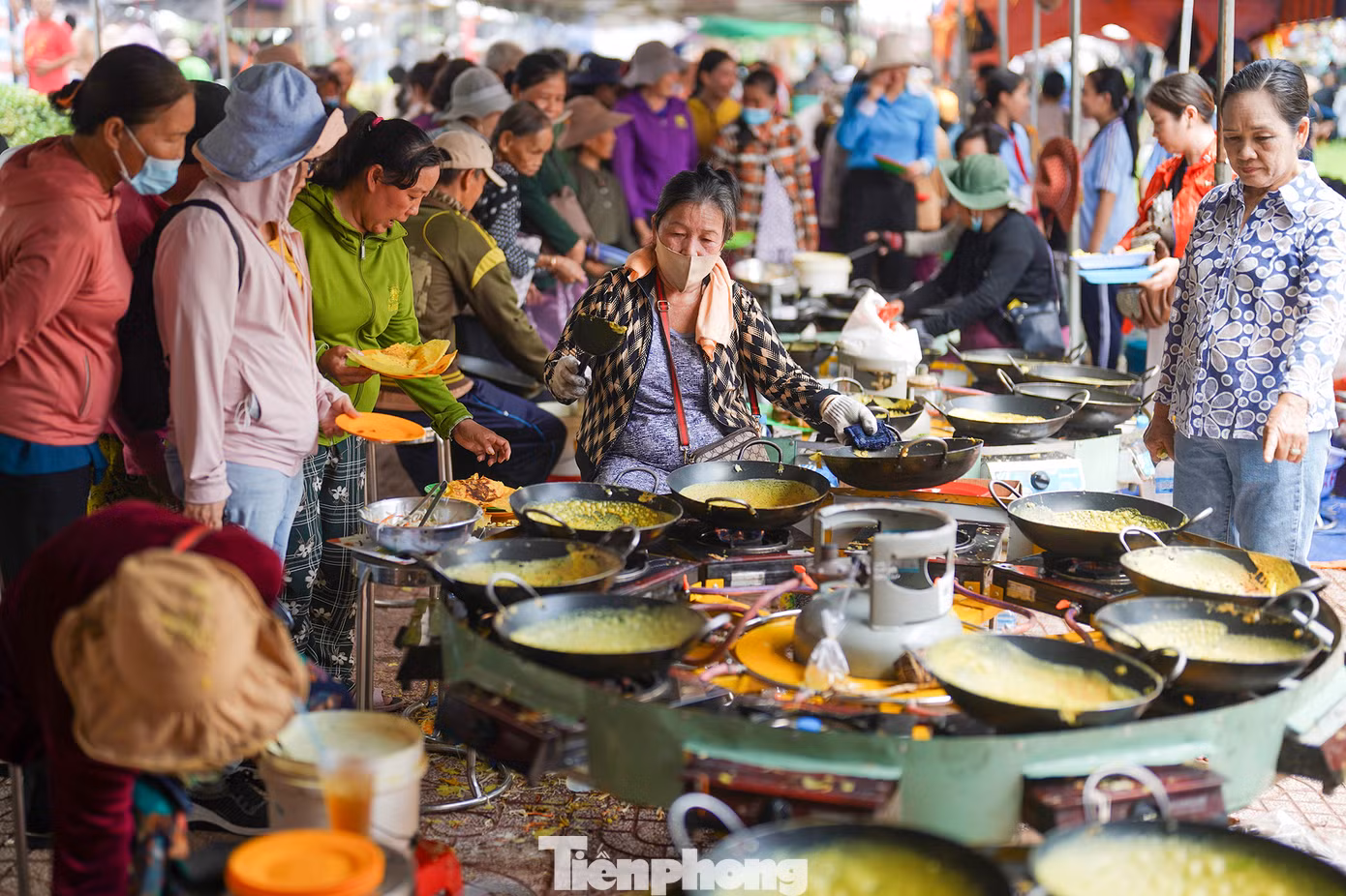 Tại khu vực đổ bánh xèo, rất đông người dân bị thu hút bởi những "cỗ máy" đổ bánh xèo của nhóm nấu ăn đến từ huyện Chợ Mới (An Giang).