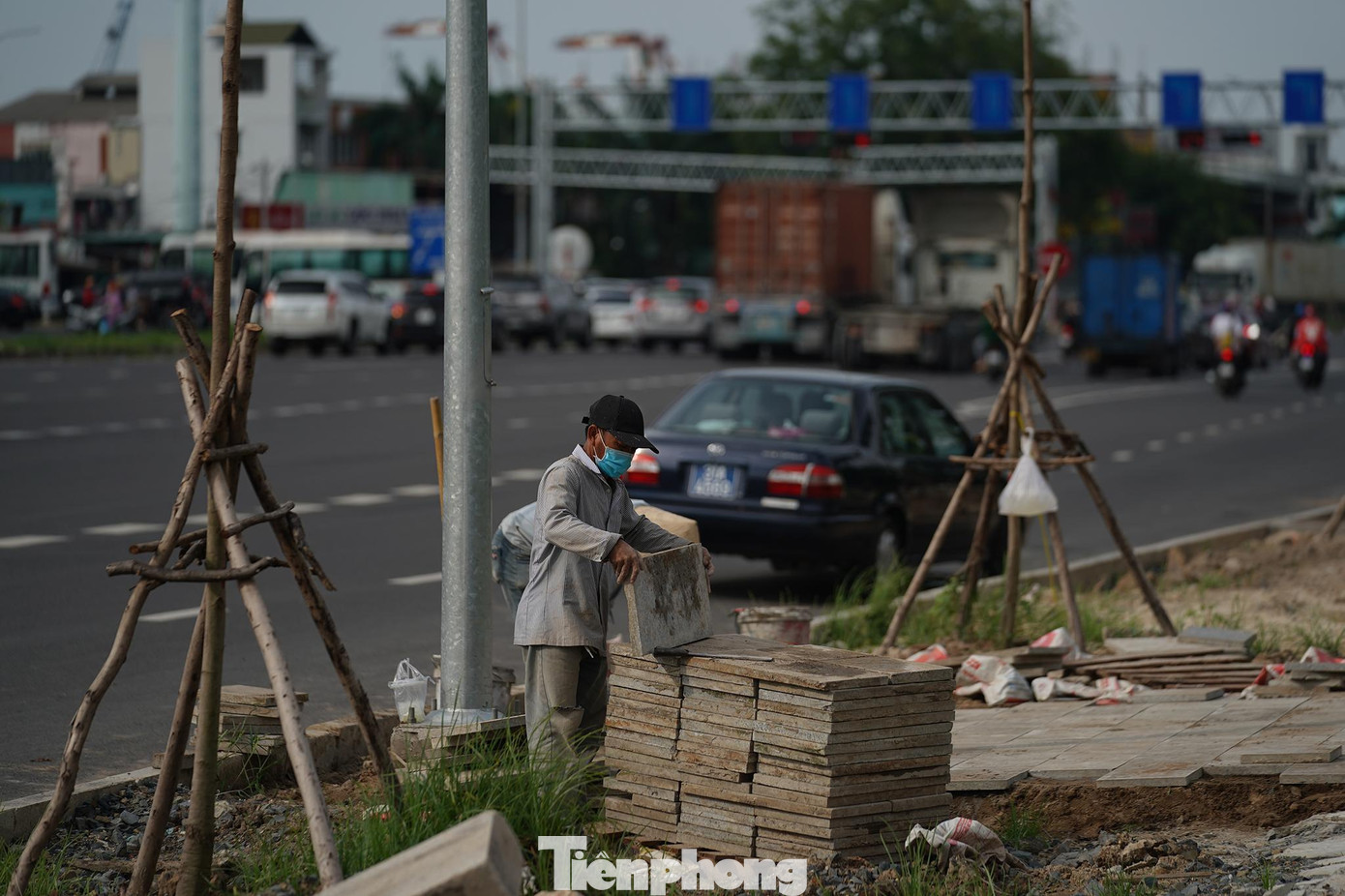 Một nhóm công nhân đang lát vỉa hè gần ngã tư Nguyễn Văn Linh - Nguyễn Thị Thập.