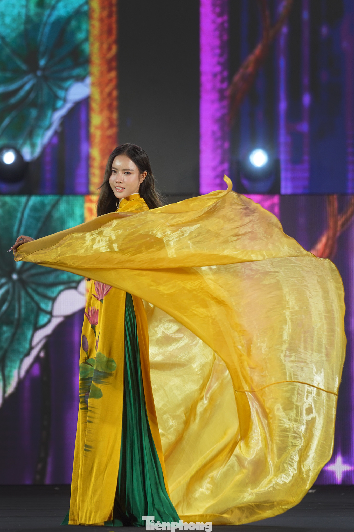 Nhà thiết kế Bảo Bảo mang đến sự kết hợp độc đáo giữa áo dài và áo bà bà trong bộ sưu tập Bức họa đồng quê. Phần tà kéo dài trên sân khấu, kết hợp sắc vàng của trang phục mang đến phần trình diễn đẹp mắt.