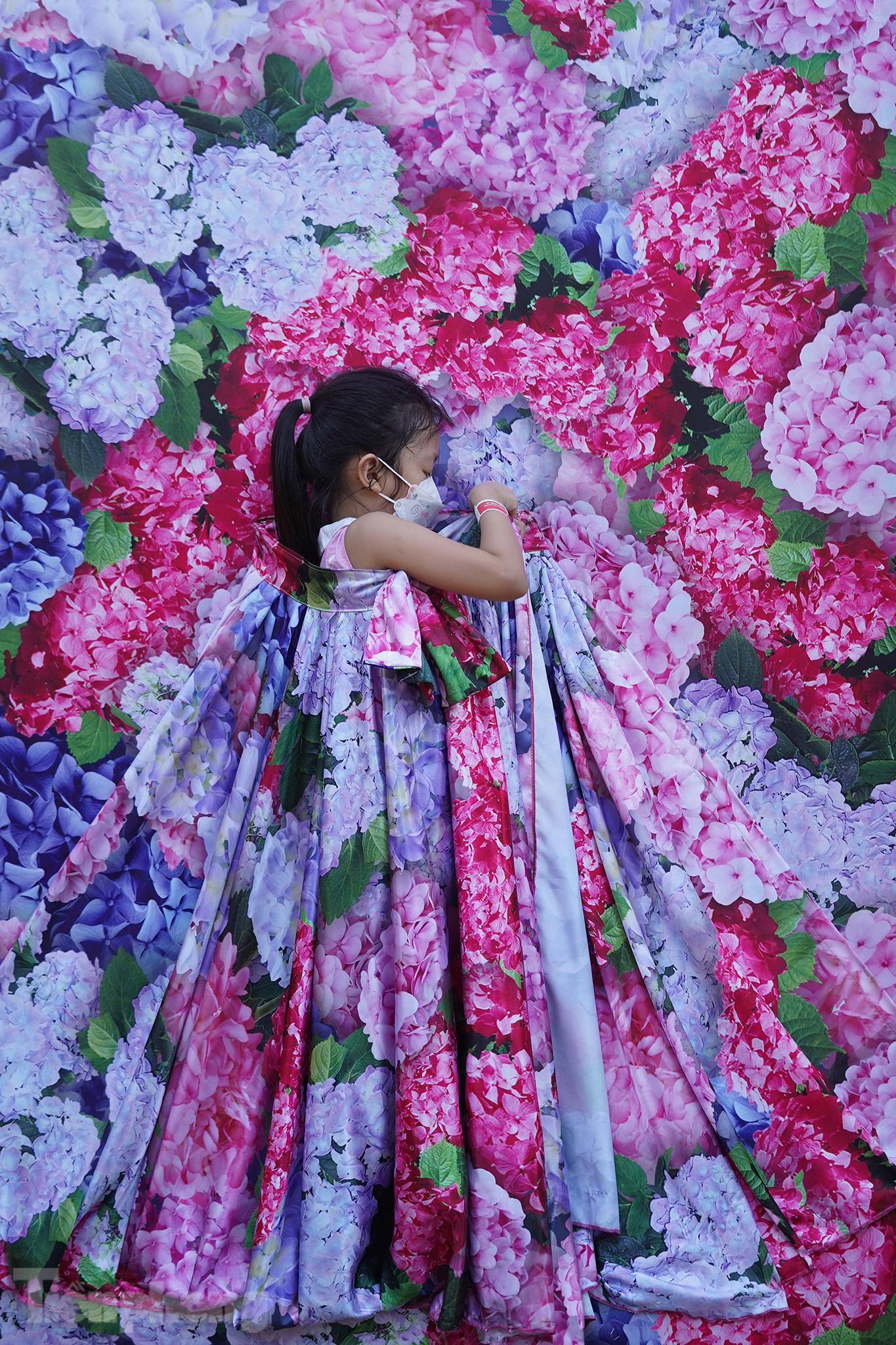 Chiếc váy tại khu vực "bức tranh Xuân" có vẻ quá khổ với vị khách nhí này. Tuy còn nhỏ nhưng em nhỏ này rất có ý thức, luôn luôn giữ chiếc khẩu trang trên mặt.