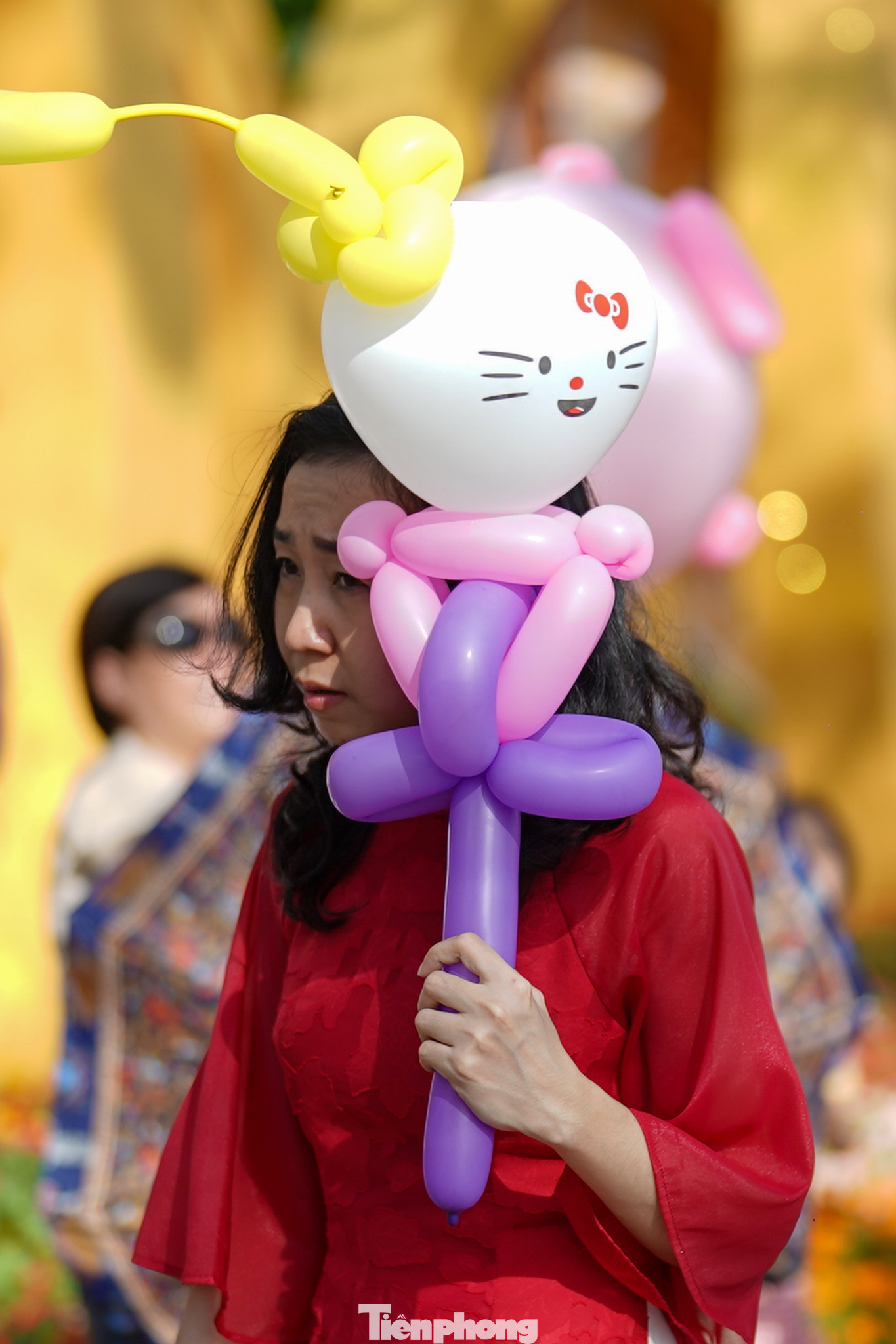 Một bạn trẻ dùng chiếc bong bóng vừa mua của chú hề để che nắng.