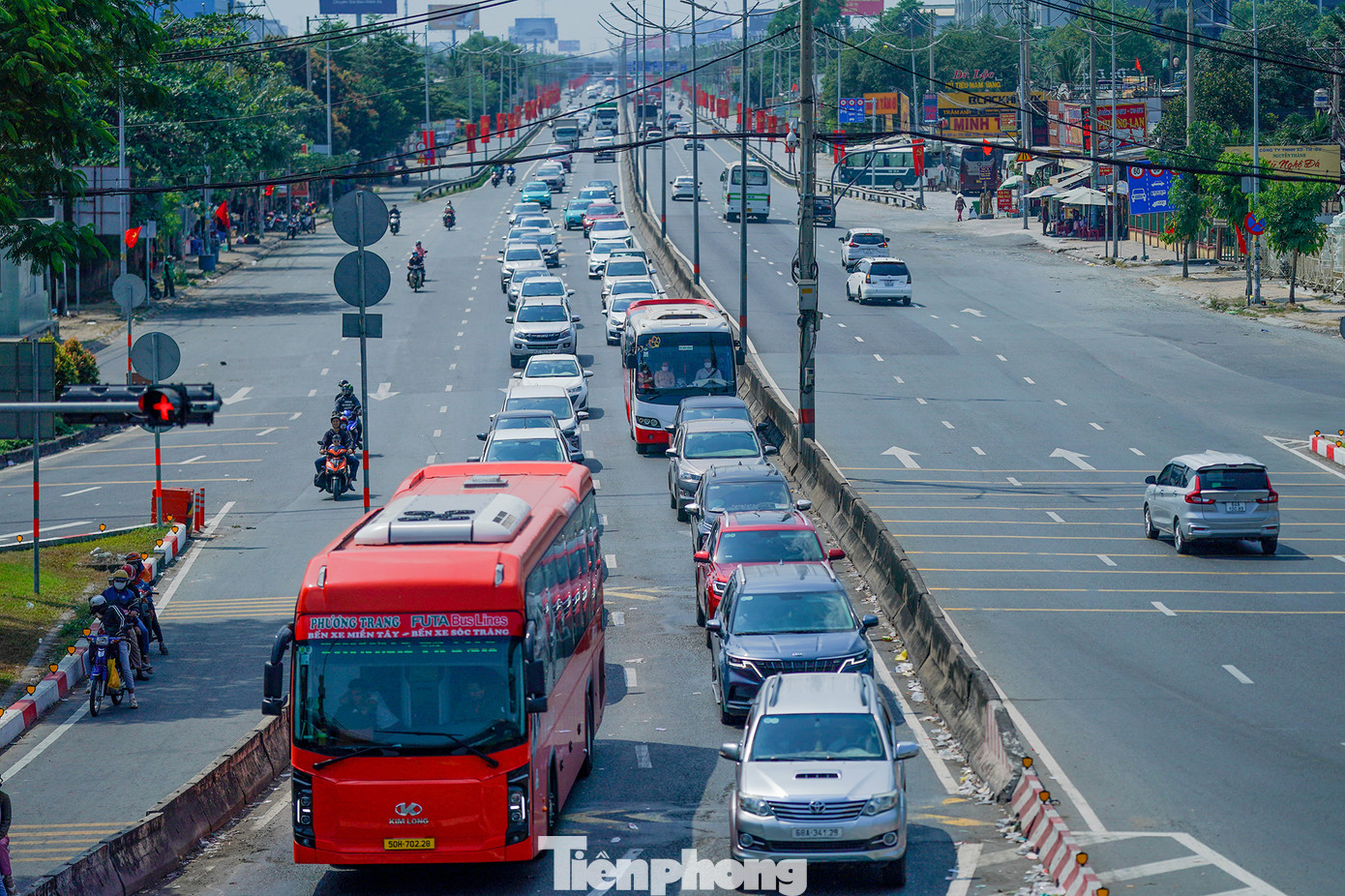 Hình ảnh đối lập bên dưới cầu vượt nút giao Bình Thuận. Dòng xe hướng ra từ cao tốc Trung Lương dừng nối dài chờ đèn đỏ, khác với chiều ngược lại, phương tiện hướng vào cao tốc thưa thớt.