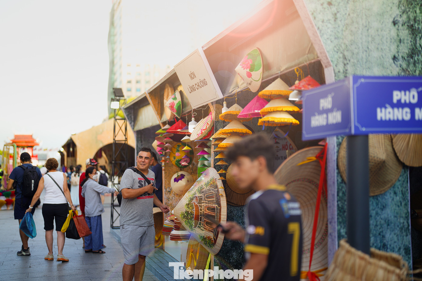 Một du khách hào hứng với sản phẩm nón Làng Chuông ở "góc đường" Phố Hàng Nón - Hàng Mã.