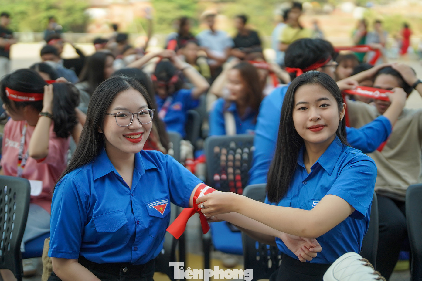 Bạn Nguyễn Thị Trang (sinh viên năm 2 Khoa Đào tạo đặc biệt trường ĐH Mở TPHCM) đang giúp bạn Mai Trần Thanh Trúc (sinh viên năm 2 Khoa Giáo dục) buộc băng đô Chủ nhật Đỏ lên tay. Bạn Trang hiến máu lần thứ 2, còn bạn Trúc đã hiến máu đến lần thứ 8.