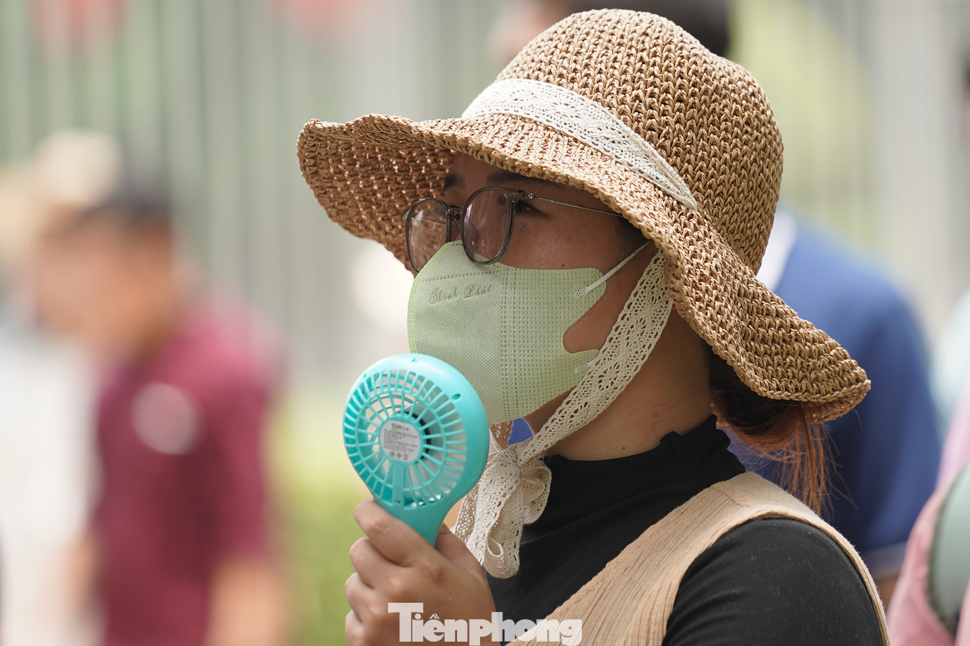 Một du khách phải dùng quạt chạy pin cầm tay.