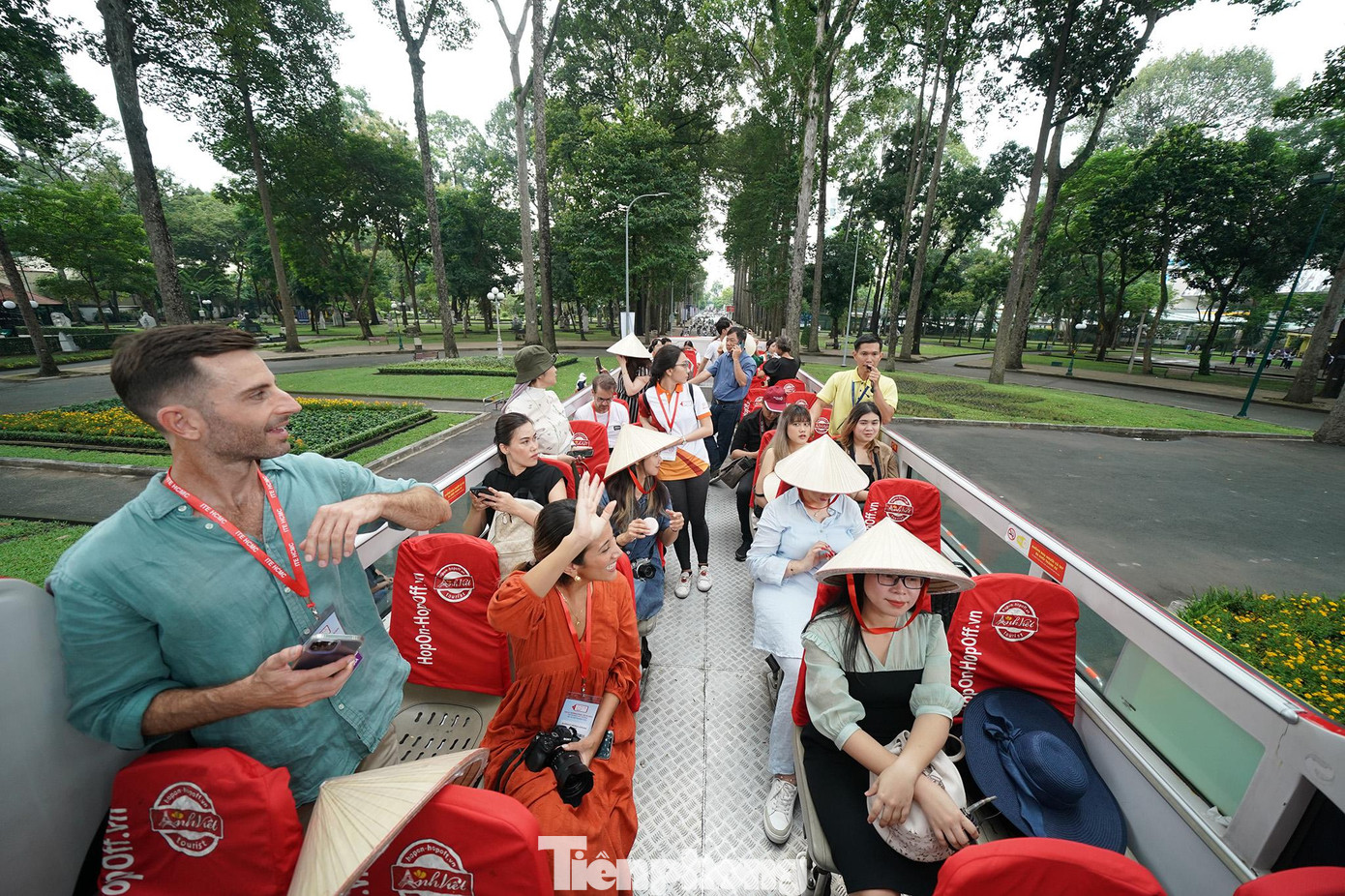 Du khách vẫy tay chào người dân đi tập thể dục buổi sáng ở công viên Tao Đàn.