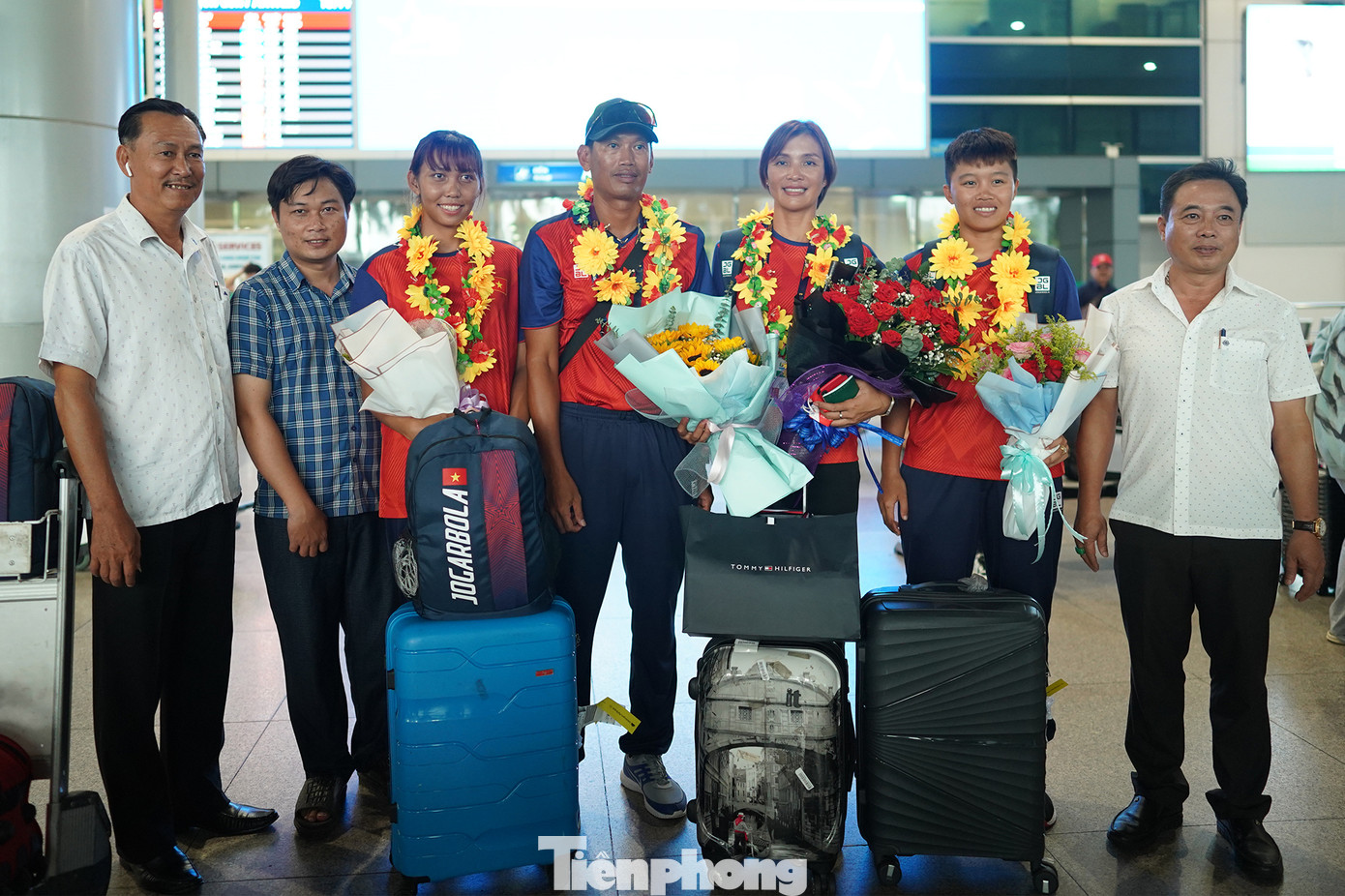 Đoàn vận động viên bóng chuyền bãi biển về đến Việt Nam và được tặng những vòng hoa.