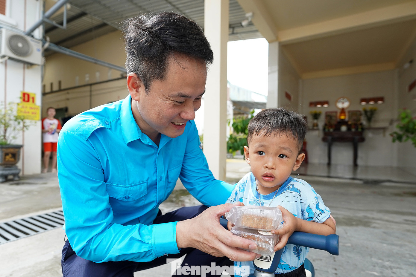 Anh Nguyễn Kim Quy tặng bánh trung thu cho bé Huy tại khu trọ. Bé Huy phải ở nhà với bà ngoại vì hôm nay ba mẹ tăng ca.