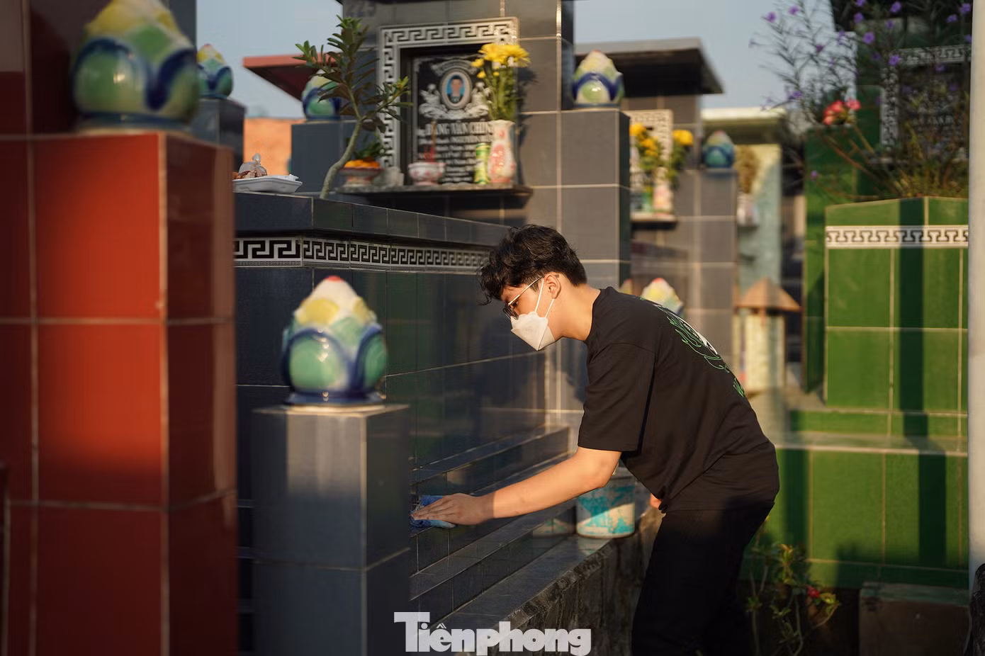 Một bạn trẻ dậy sớm, chuẩn bị các vật dụng để lau rửa mộ người thân.