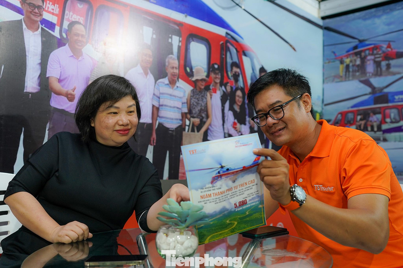 Một du khách đang tìm hiểu tour "ngắm nhìn thành phố từ trên cao" khi di chuyển bằng trực thăng, có giá chỉ 5 triệu đồng.