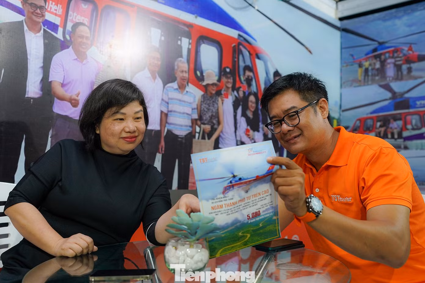 Một du khách đang tìm hiểu tour "ngắm nhìn thành phố từ trên cao" khi di chuyển bằng trực thăng, có giá chỉ 5 triệu đồng.