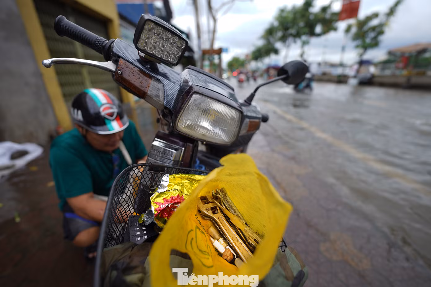 Triều cường buộc người dân nơi đây phải thích nghi, tìm mọi cách chống chọi. "Bị chết máy riết quen, tôi mang cả mớ bu-gi (bộ phận đánh lửa xe máy) theo, ướt là thay", ông Ngà (ngụ phường Tân Thuận Tây, Quận 7) chia sẻ khi đang thay chiếc bu-gi mới.