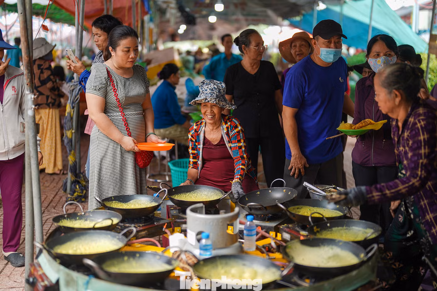 Tuy công việc vất vả nhưng nhóm đổ bánh xèo Tư Cuôl (An Giang) vẫn luôn tươi vui khi phục vụ. "Càng đổ càng vui, chả thấy mệt. Thấy người dân đứng chờ bánh, rồi xin thêm mình tự nhiên quên hết mệt", cô 6 Mai (70 tuổi) chia sẻ.