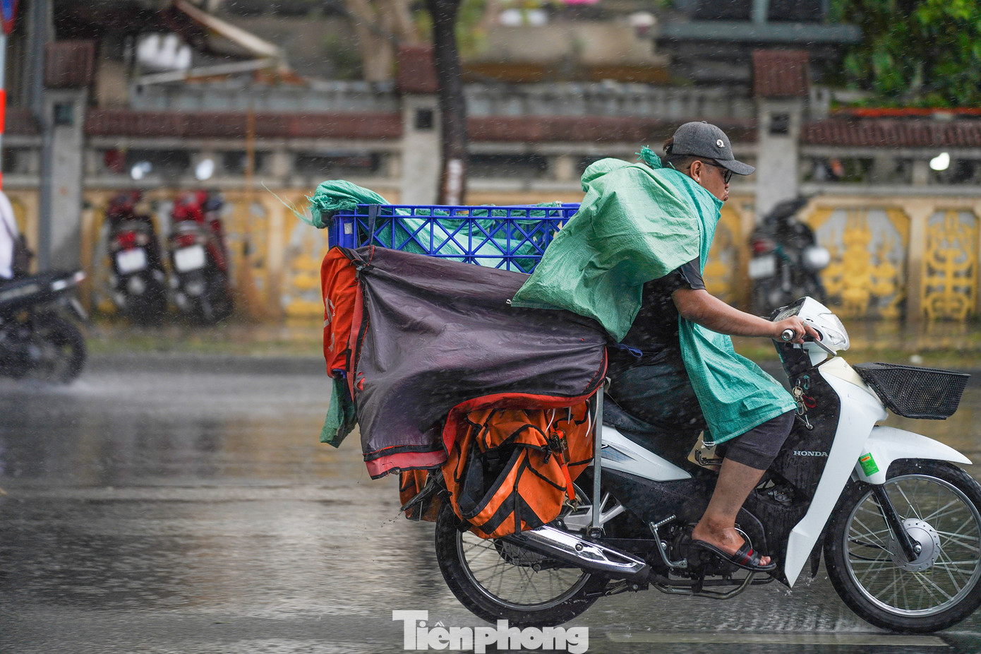 Một người giao hàng khác lấy bao đựng hàng che tạm, chạy trong cơn mưa để kịp giao hàng.