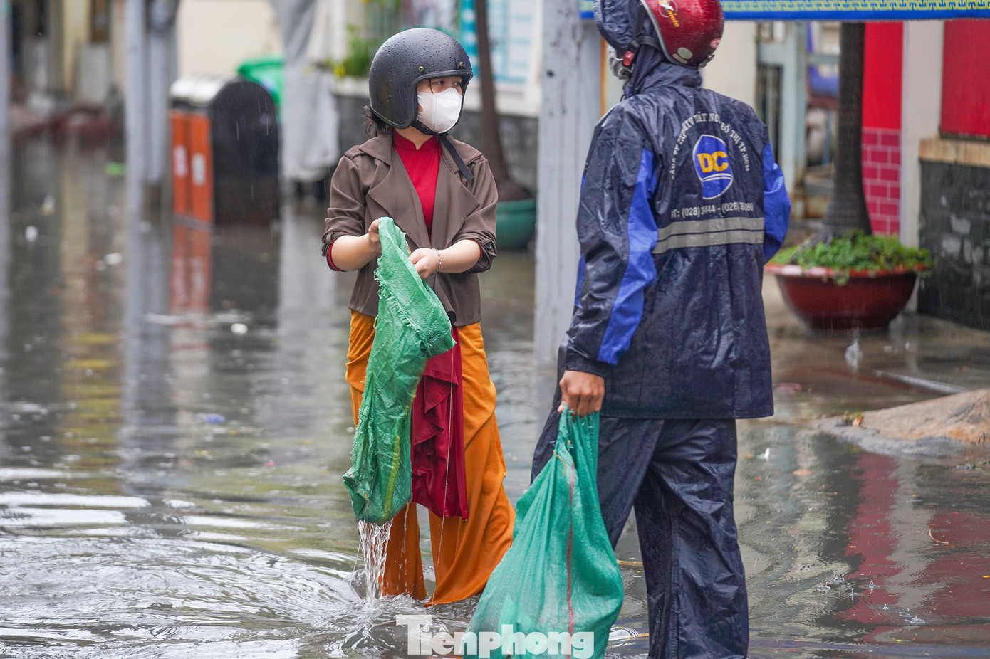Một thiếu nữ áo dài xắn tay dọn rác phụ công nhân thoát nước. Một thiếu nữ áo dài xắn tay dọn rác phụ công nhân thoát nước.
