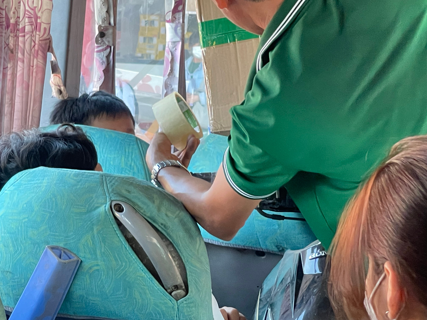 Chiếc thùng hàng quá khổ. Tài xế phải dùng băng keo cố định lên yên chiếc xe máy, chắn luôn lối đi của hai nam hành khách.